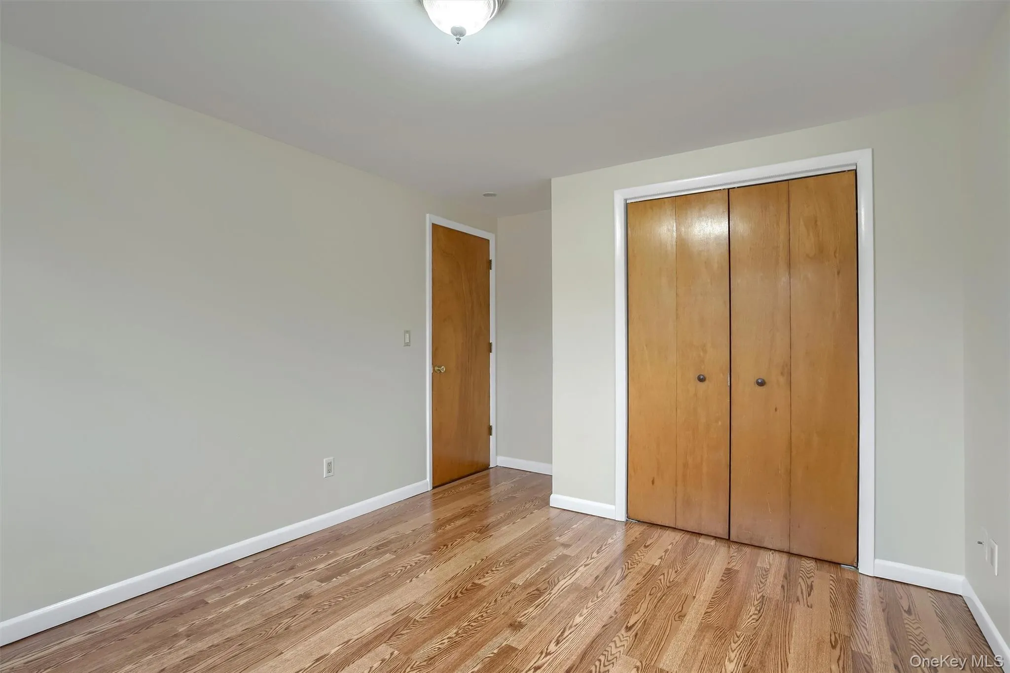 Unfurnished bedroom featuring a closet and light wood-style floors Unfurnished bedroom featuring a closet and light wood-style floors