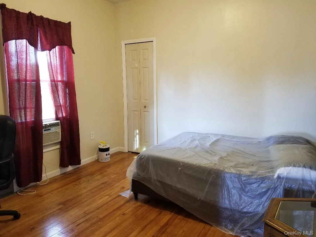 Bedroom featuring hardwood / wood-style flooring and cooling unit Bedroom featuring hardwood / wood-style flooring and cooling unit