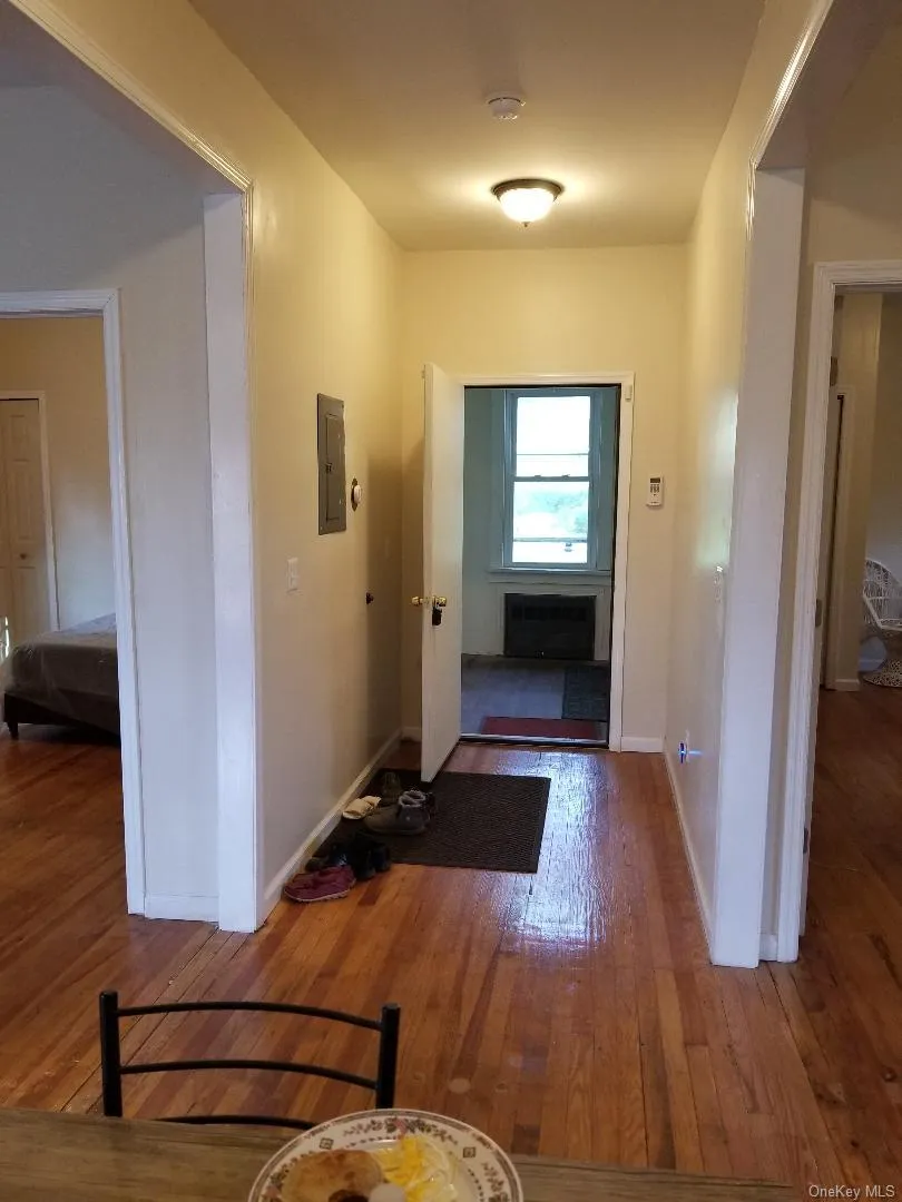 Corridor featuring hardwood / wood-style floors and electric panel Corridor featuring hardwood / wood-style floors and electric panel