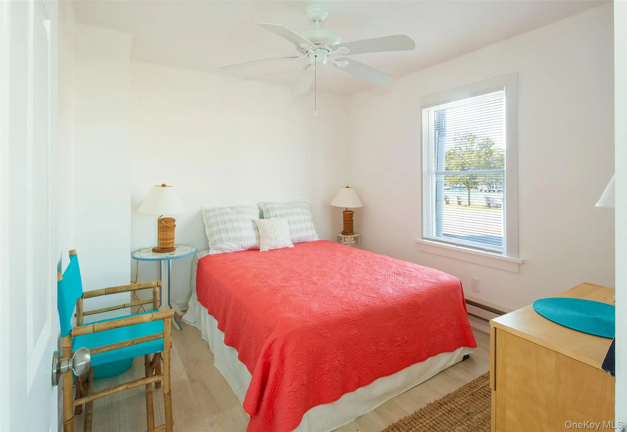 Bedroom with wood finished floors, a ceiling fan, and a baseboard heating unit Bedroom with wood finished floors, a ceiling fan, and a baseboard heating unit