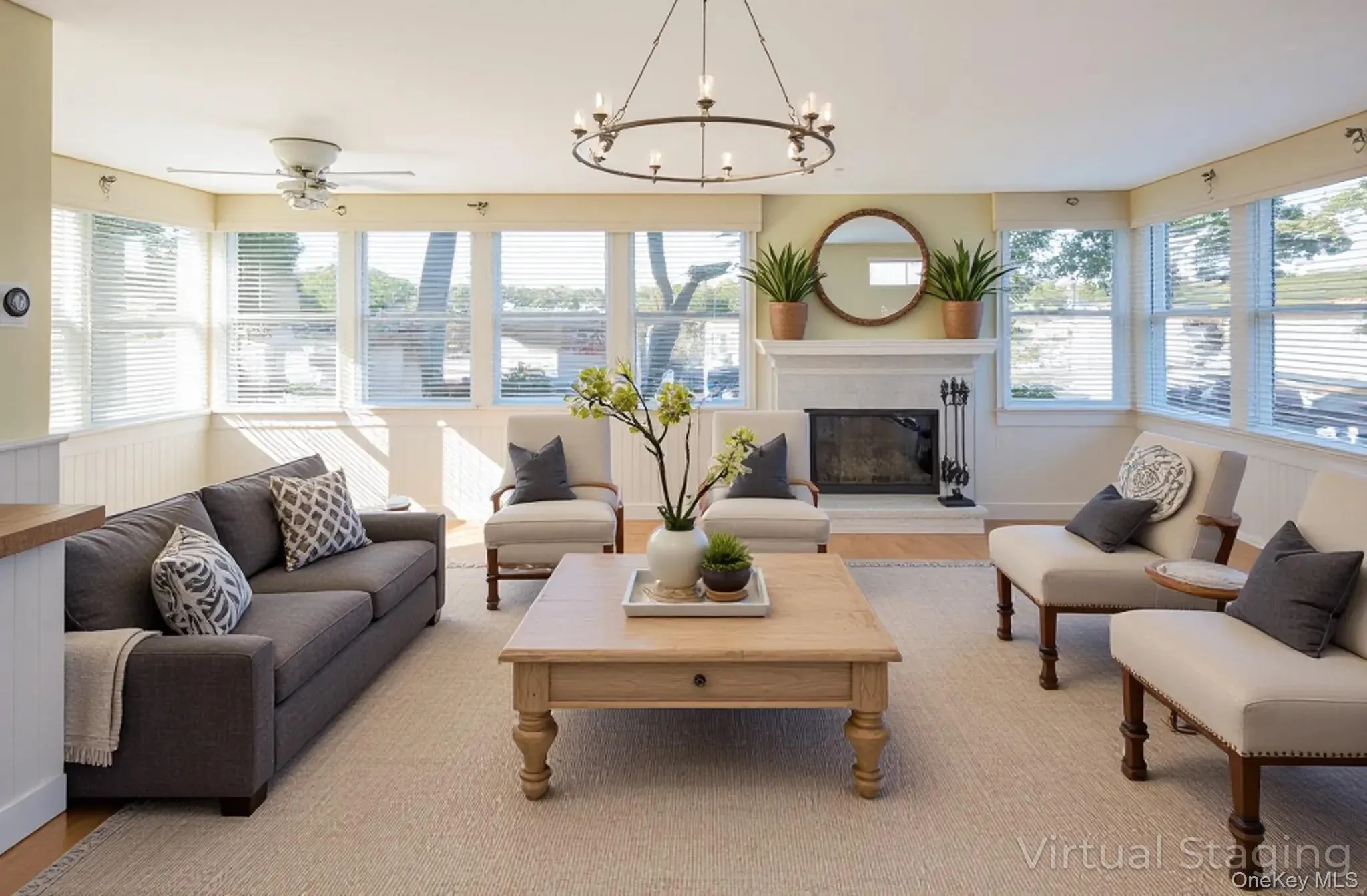 Virtually Staged Living area featuring a glass covered fireplace, a chandelier, wood finished floors, a wainscoted wall, and ceiling fan Virtually Staged Living area featuring a glass covered fireplace, a chandelier, wood finished floors, a wainscoted wall, and ceiling fan