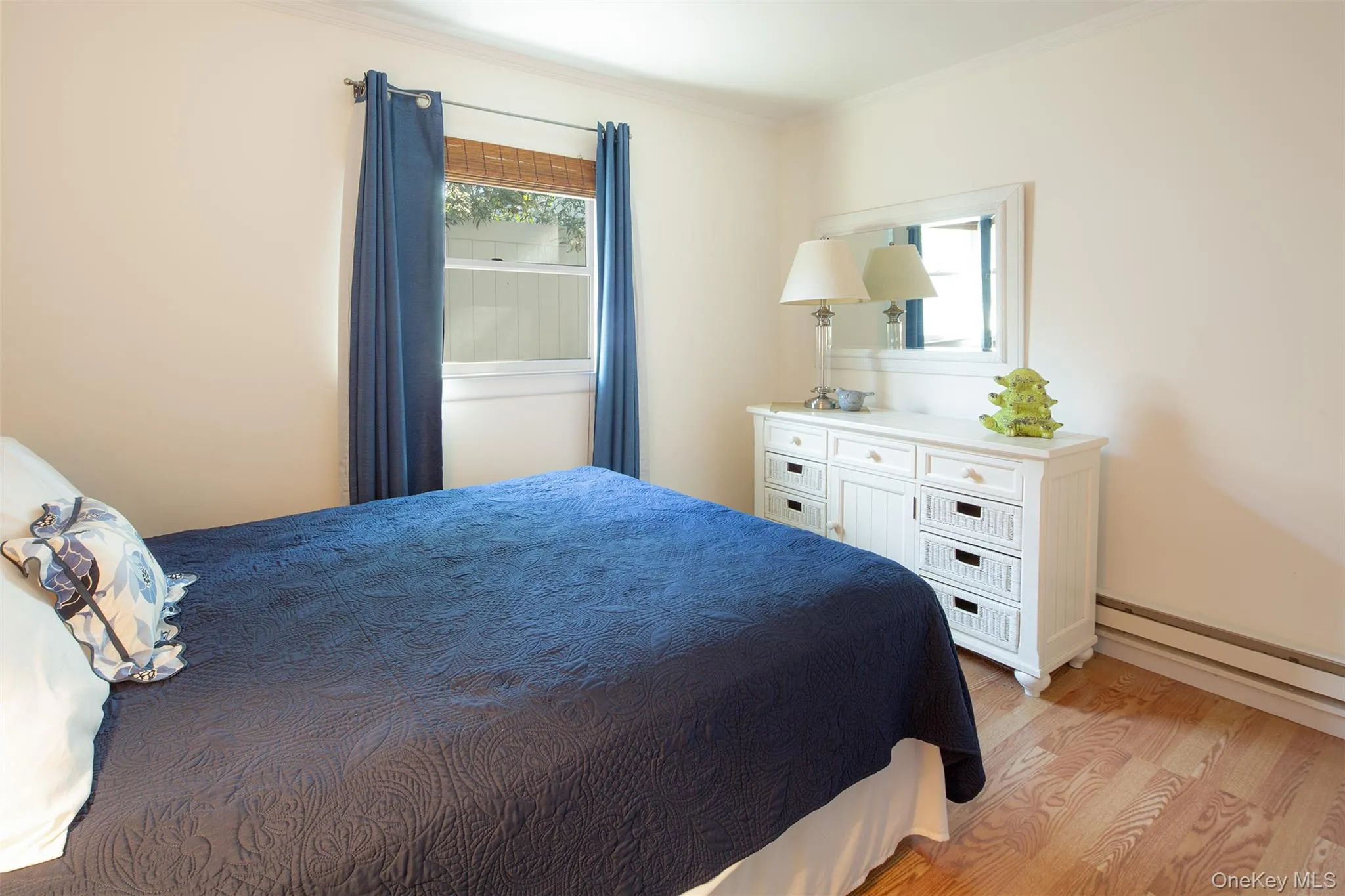 Bedroom featuring light wood-style flooring and ornamental molding Bedroom featuring light wood-style flooring and ornamental molding