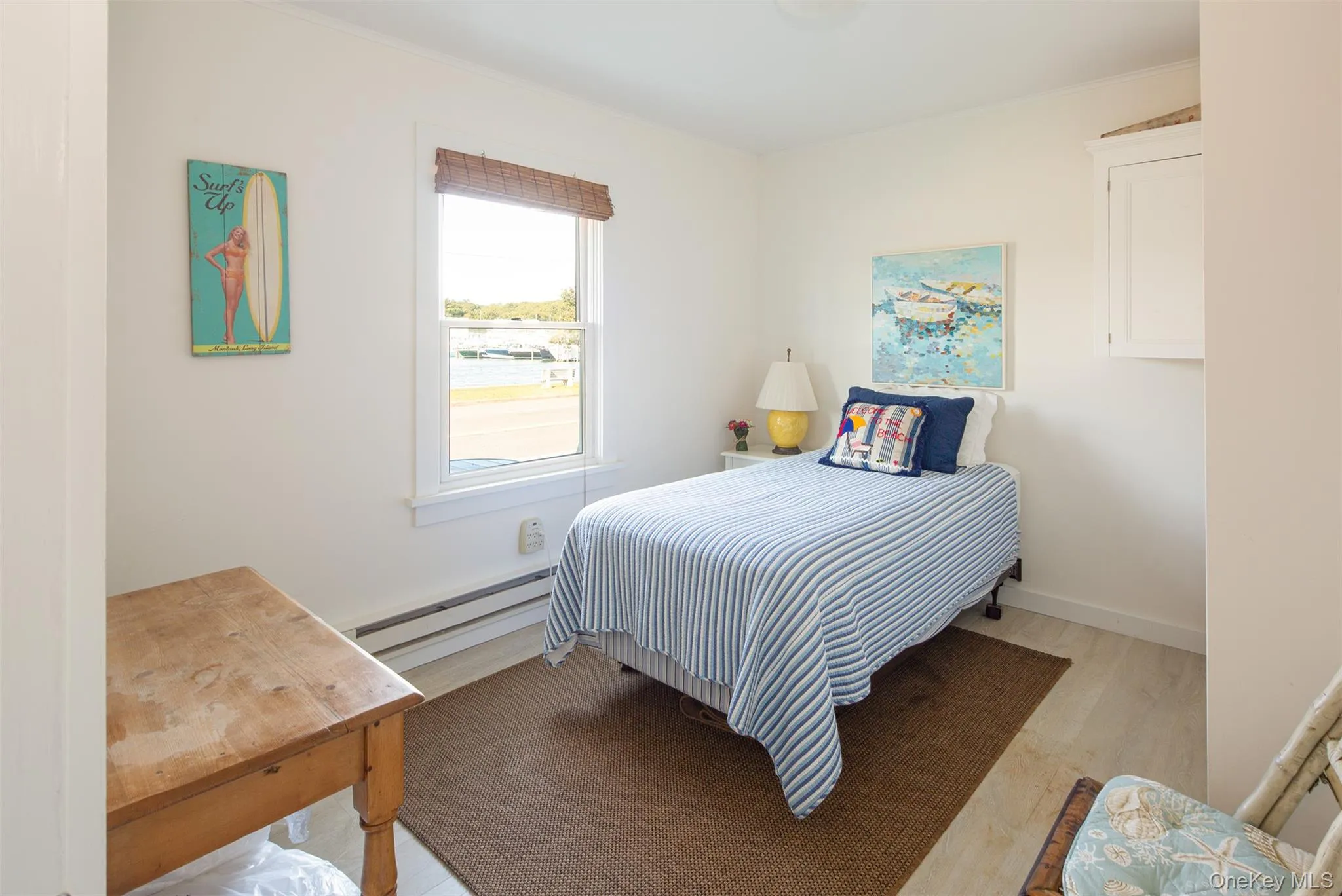 Bedroom with a baseboard heating unit and light wood finished floors Bedroom with a baseboard heating unit and light wood finished floors