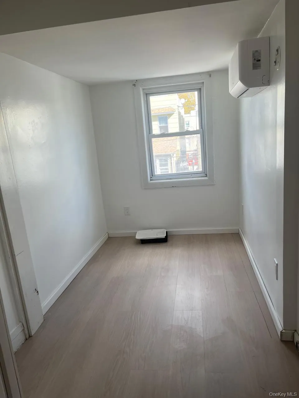 Spare room featuring light wood finished floors and a wall mounted air conditioner Spare room featuring light wood finished floors and a wall mounted air conditioner