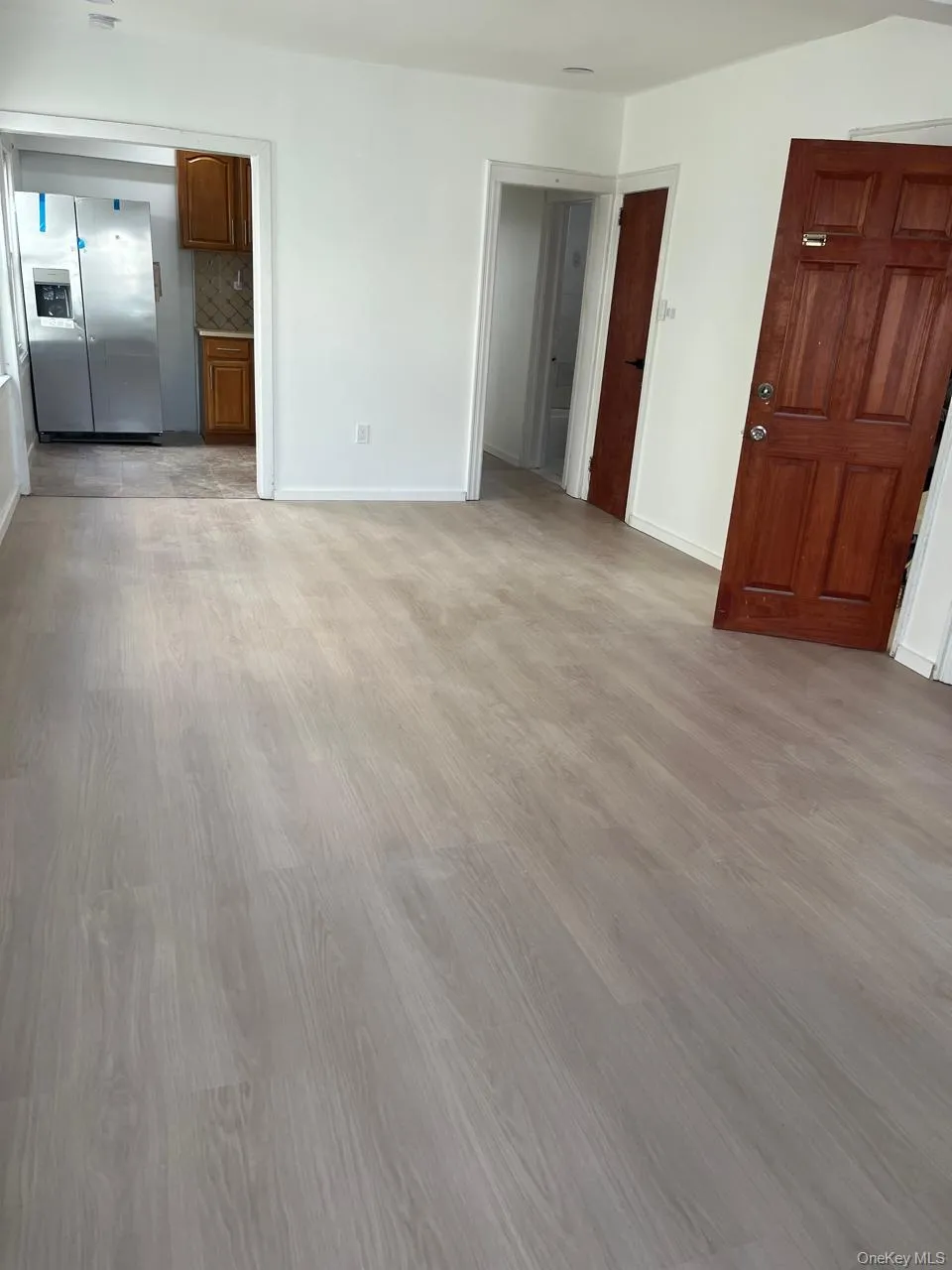 Unfurnished living room with light wood-style flooring and baseboards Unfurnished living room with light wood-style flooring and baseboards