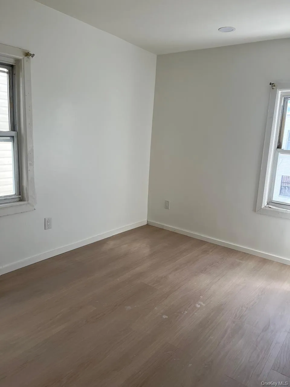 Empty room with healthy amount of natural light and wood finished floors Empty room with healthy amount of natural light and wood finished floors