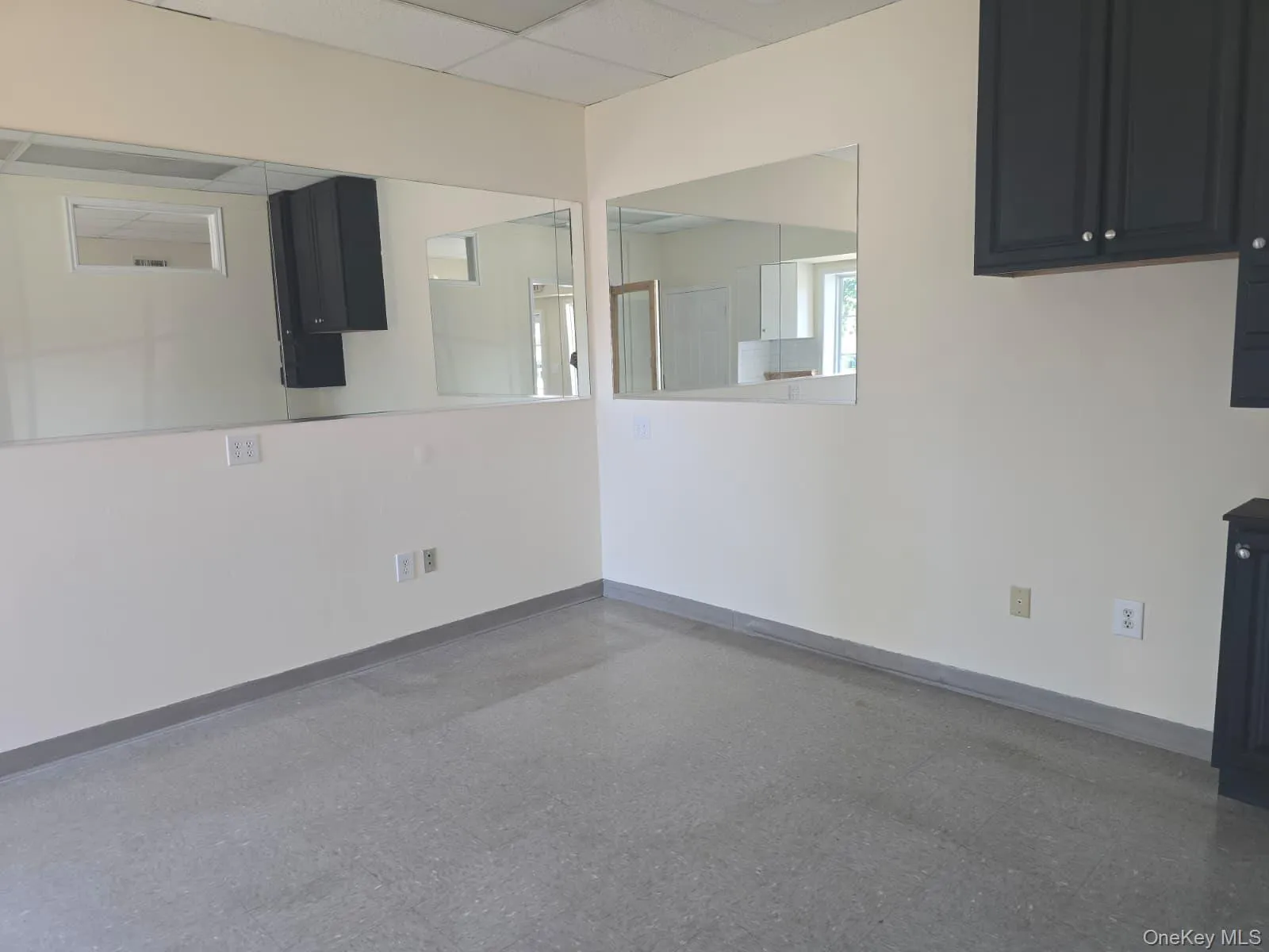 Unfurnished dining area featuring a drop ceiling and baseboards Unfurnished dining area featuring a drop ceiling and baseboards