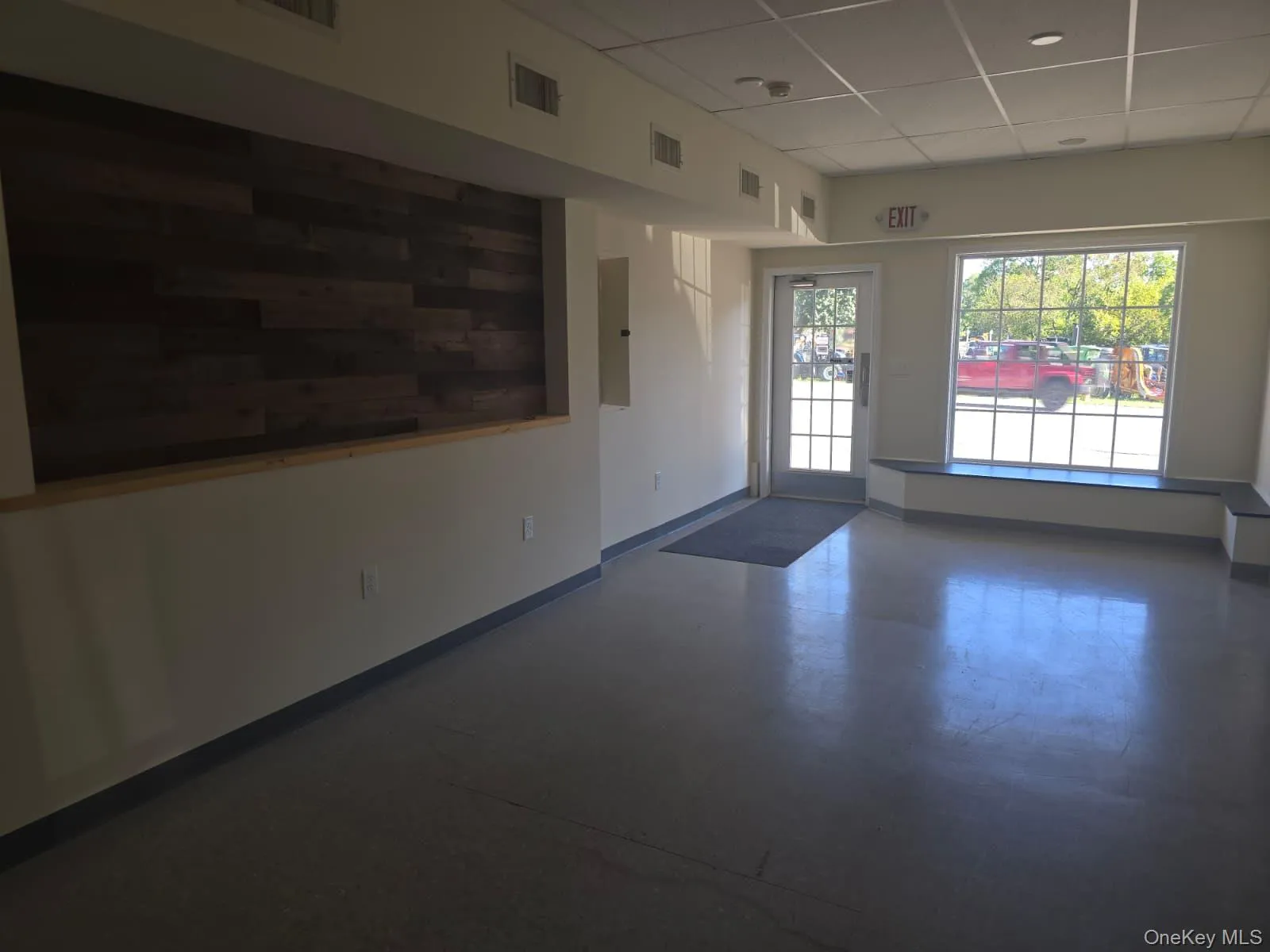 Unfurnished room with a drop ceiling and finished concrete flooring Unfurnished room with a drop ceiling and finished concrete flooring