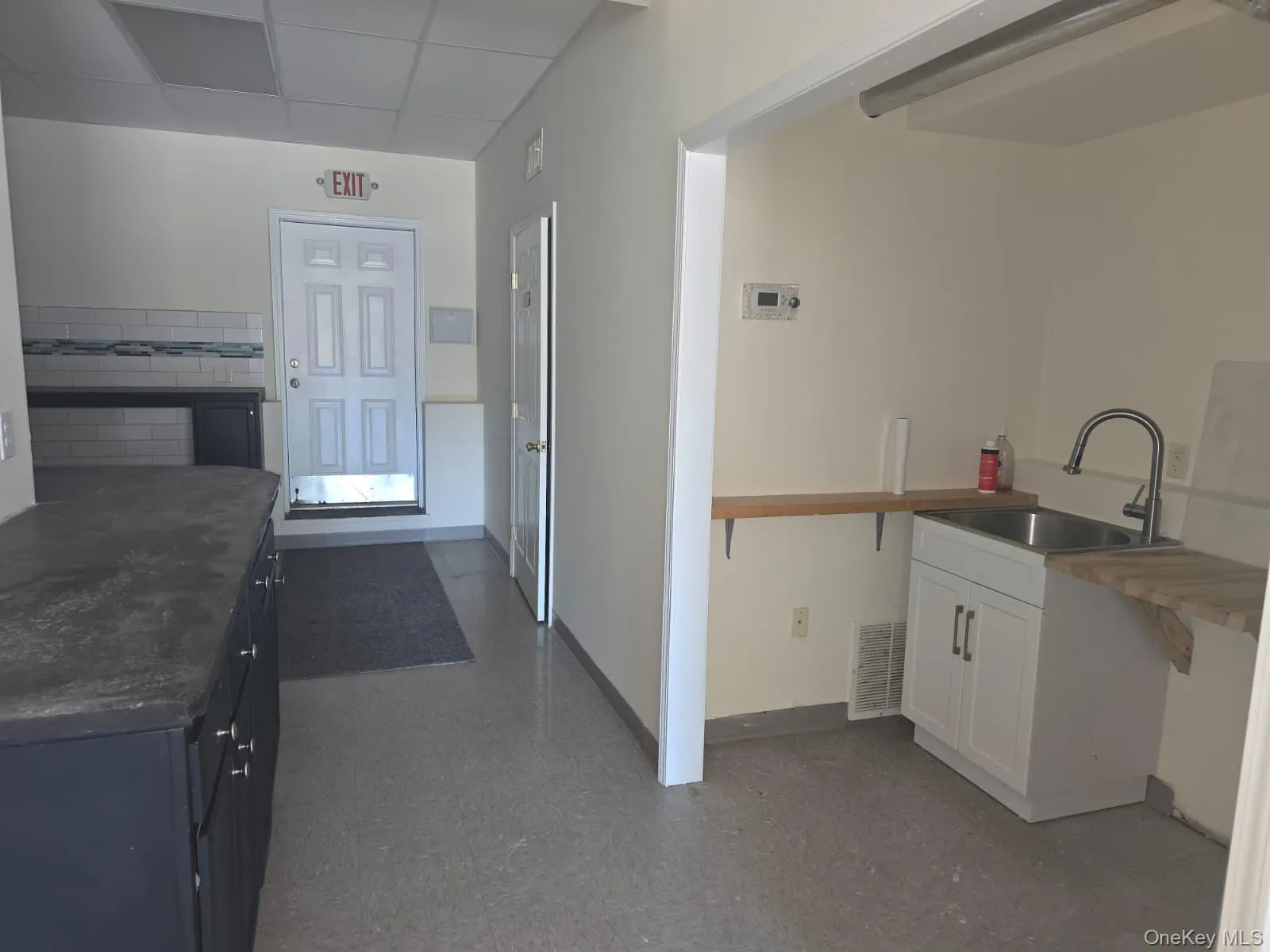 Kitchen with a paneled ceiling and white cabinets Kitchen with a paneled ceiling and white cabinets