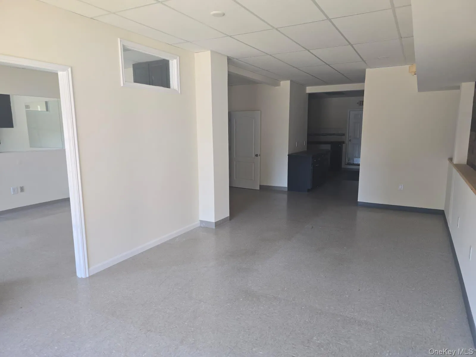 Spare room featuring a drop ceiling and speckled floor Spare room featuring a drop ceiling and speckled floor