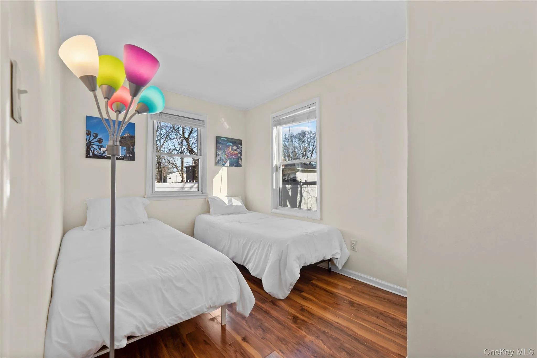 Bedroom featuring dark wood finished floors and baseboards Bedroom featuring dark wood finished floors and baseboards