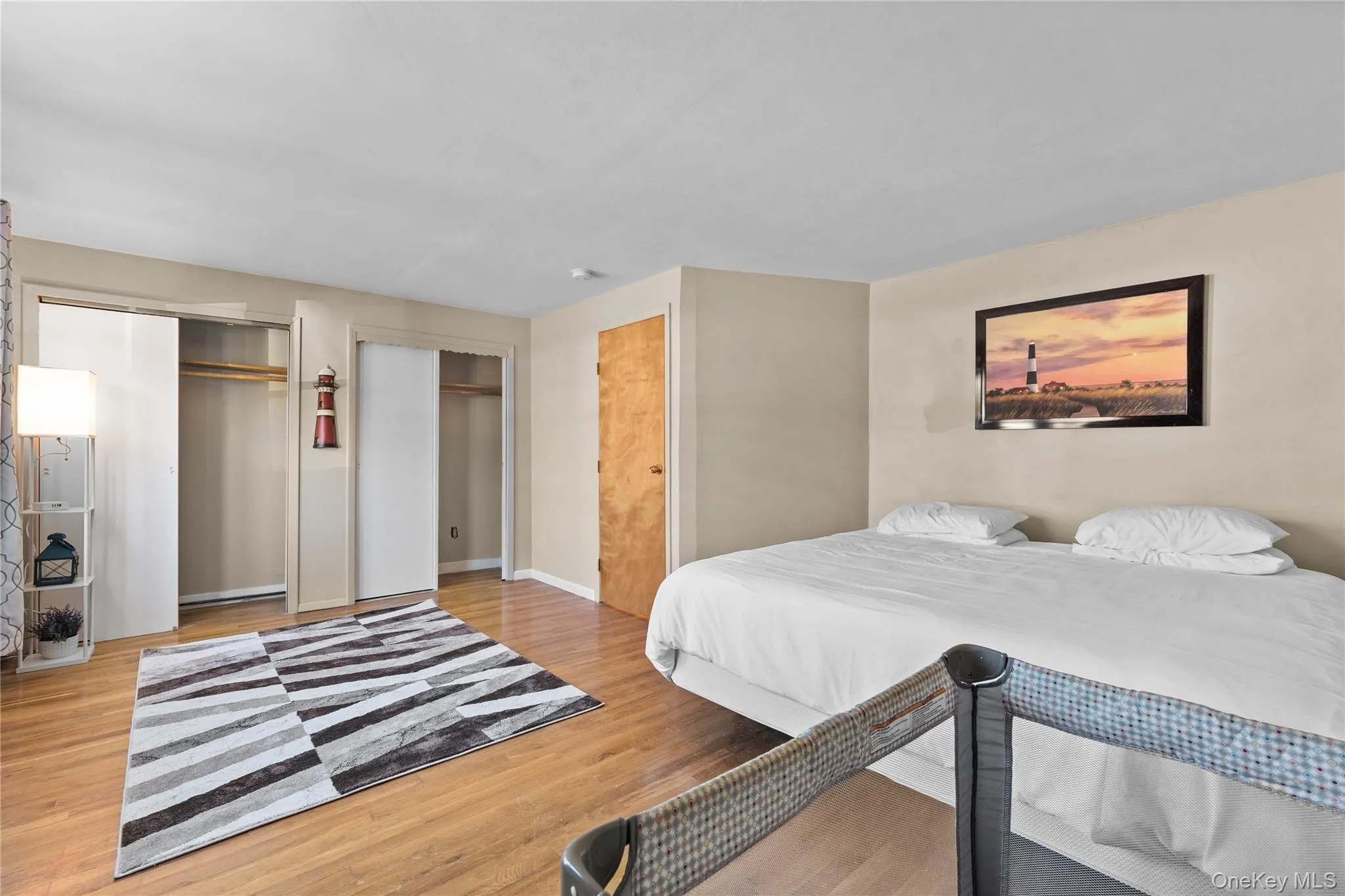 Bedroom with multiple closets and light wood-type flooring Bedroom with multiple closets and light wood-type flooring