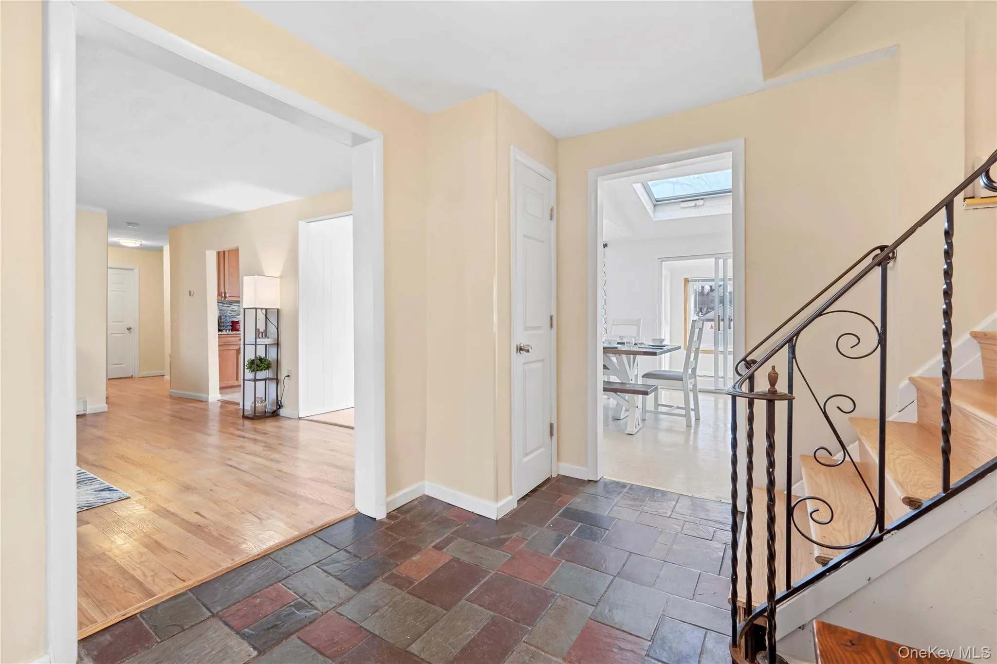 Foyer featuring a skylight, stone tile flooring, and stairs Foyer featuring a skylight, stone tile flooring, and stairs