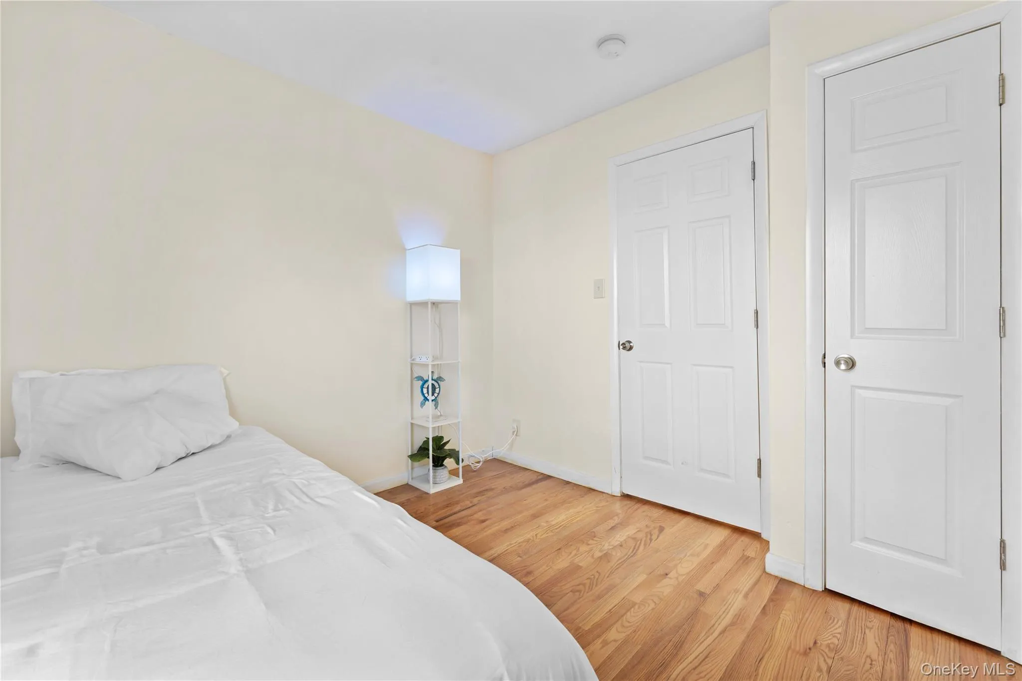 Bedroom with light wood-type flooring and baseboards Bedroom with light wood-type flooring and baseboards