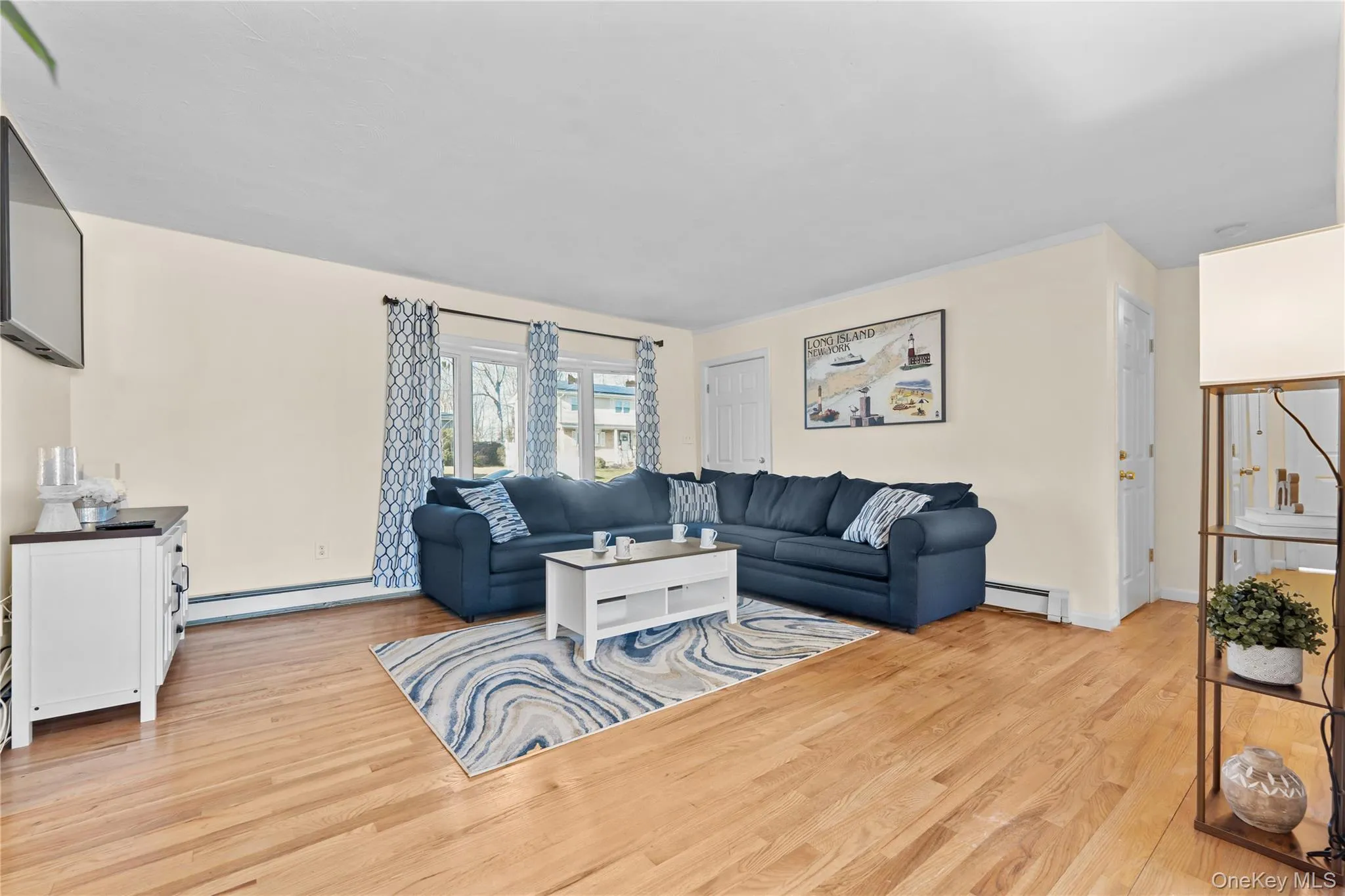 Living area featuring light wood-style floors and a baseboard heating unit Living area featuring light wood-style floors and a baseboard heating unit