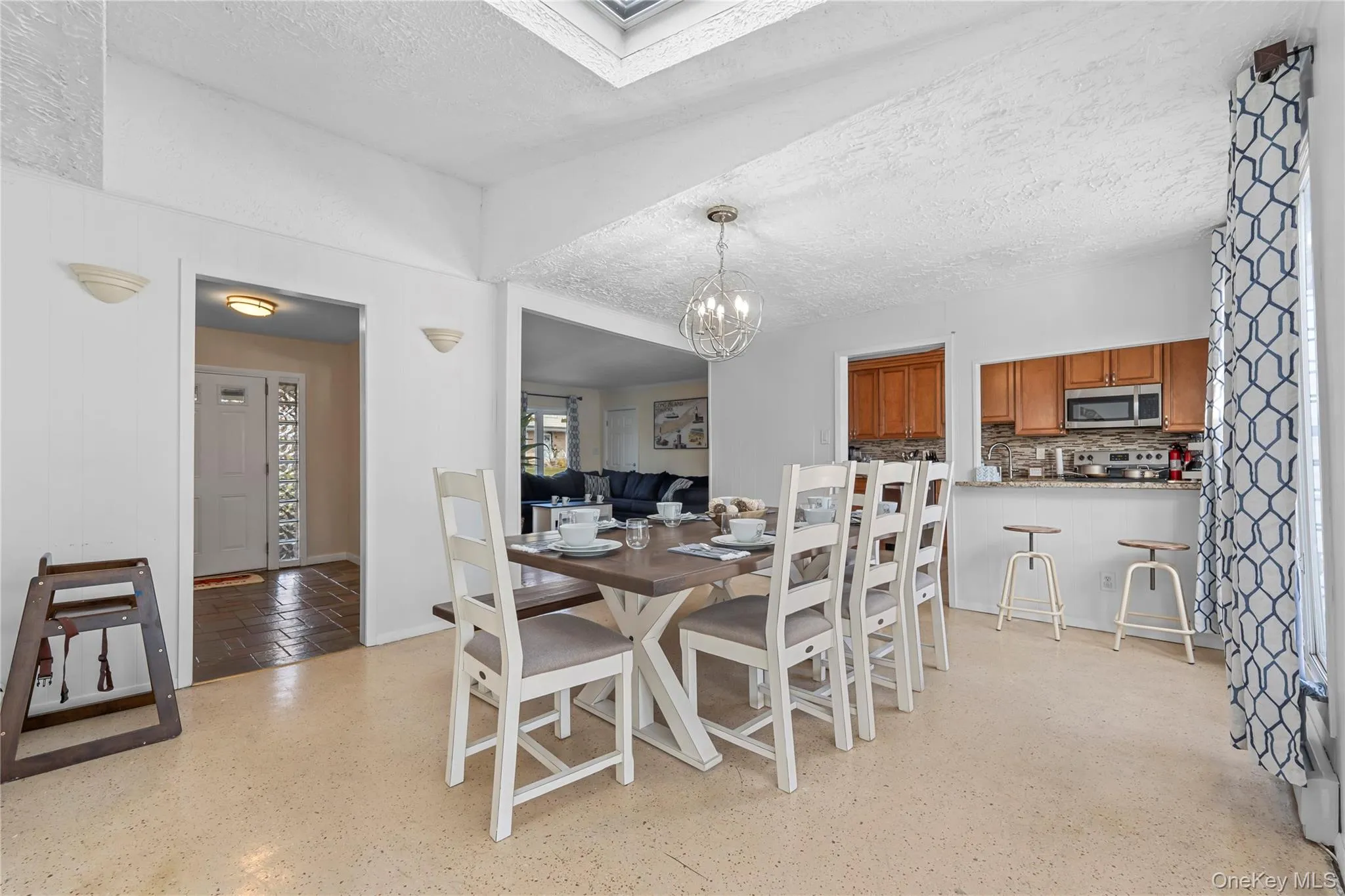 Dining area featuring a textured ceiling and a chandelier Dining area featuring a textured ceiling and a chandelier