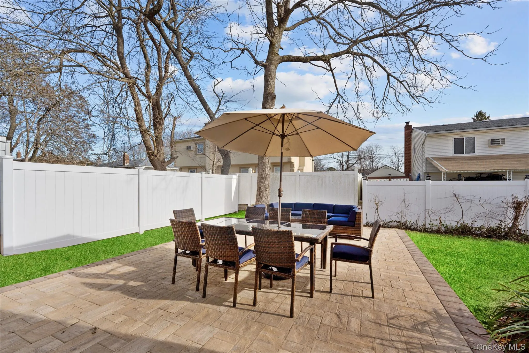 Fenced backyard with an outdoor hangout area, outdoor dining area, and a patio area Fenced backyard with an outdoor hangout area, outdoor dining area, and a patio area