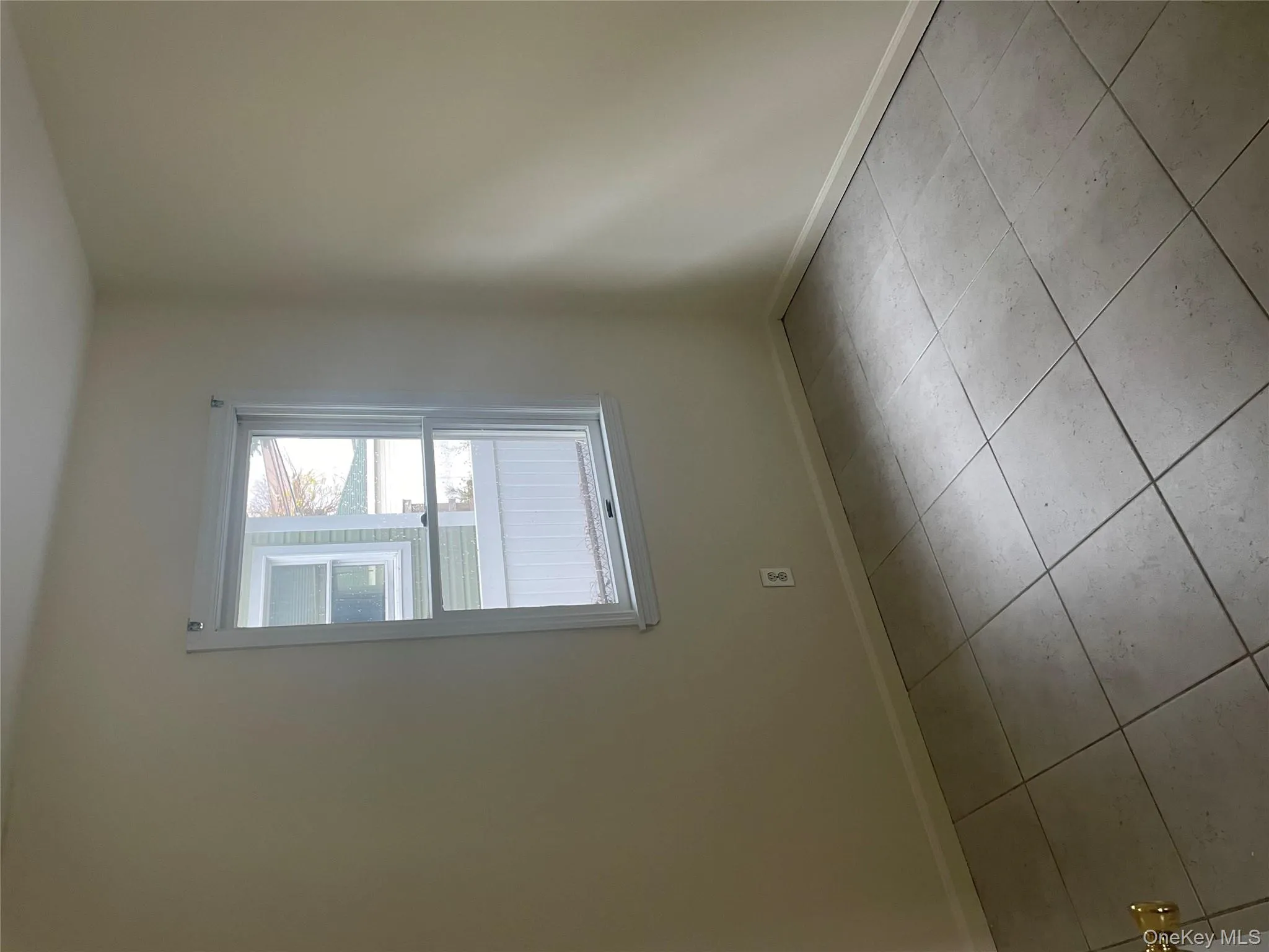 Unfurnished room with baseboards and light tile patterned floors Unfurnished room with baseboards and light tile patterned floors