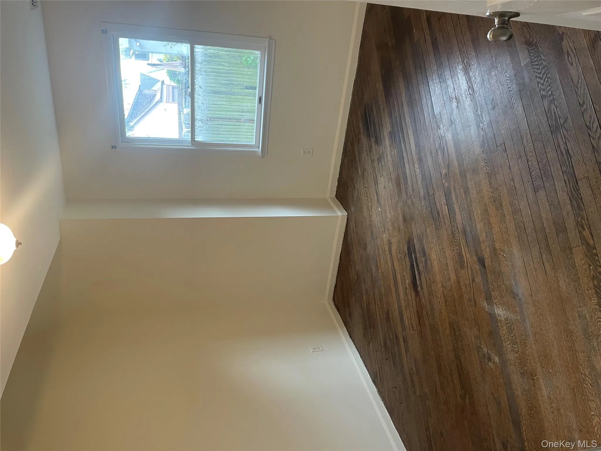 Unfurnished room featuring dark wood-style flooring and baseboards Unfurnished room featuring dark wood-style flooring and baseboards