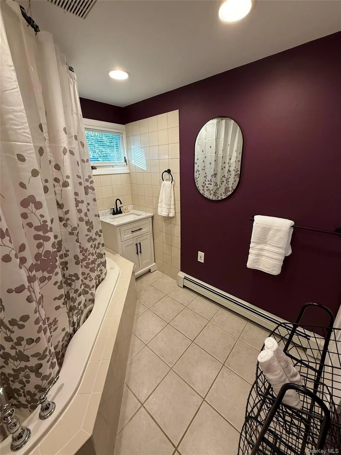 Bathroom with light tile patterned floors, a stall shower, a baseboard heating unit, recessed lighting, and tile walls Bathroom with light tile patterned floors, a stall shower, a baseboard heating unit, recessed lighting, and tile walls