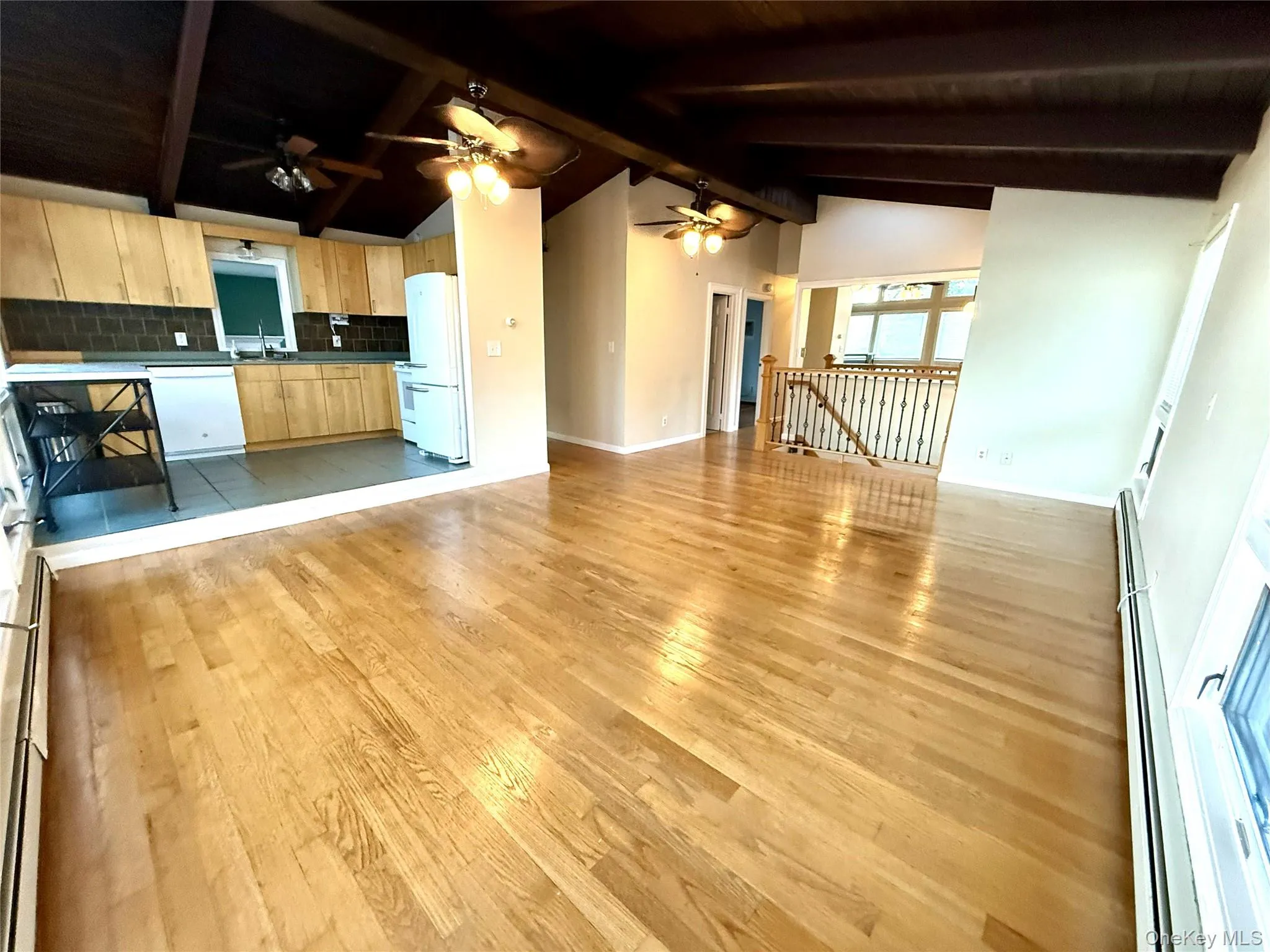 Unfurnished living room with ceiling fan, light wood finished floors, baseboard heating, and wooden ceiling Unfurnished living room with ceiling fan, light wood finished floors, baseboard heating, and wooden ceiling