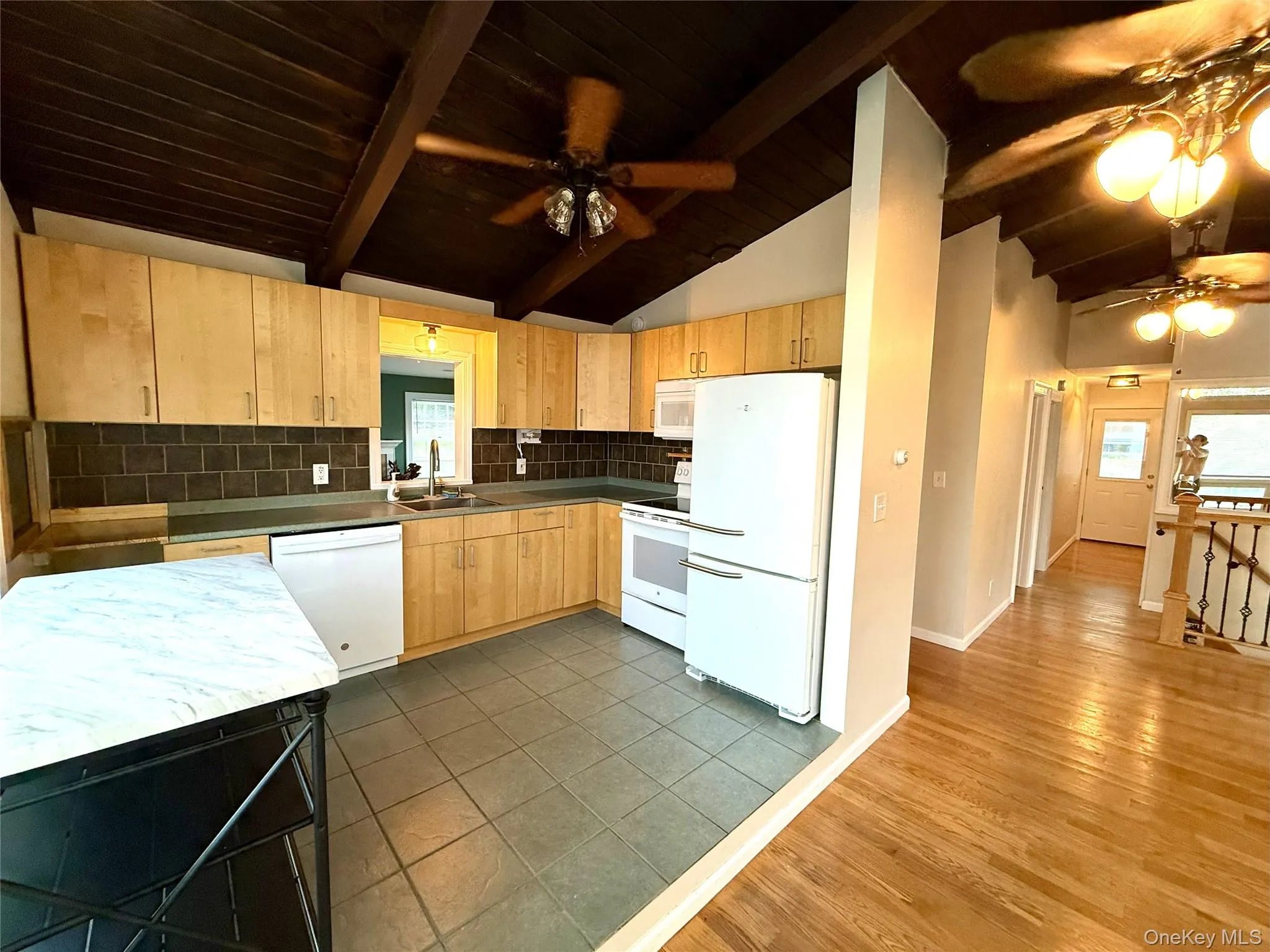 Kitchen featuring backsplash, white appliances, a ceiling fan, light brown cabinets, and dark wood-style floors Kitchen featuring backsplash, white appliances, a ceiling fan, light brown cabinets, and dark wood-style floors