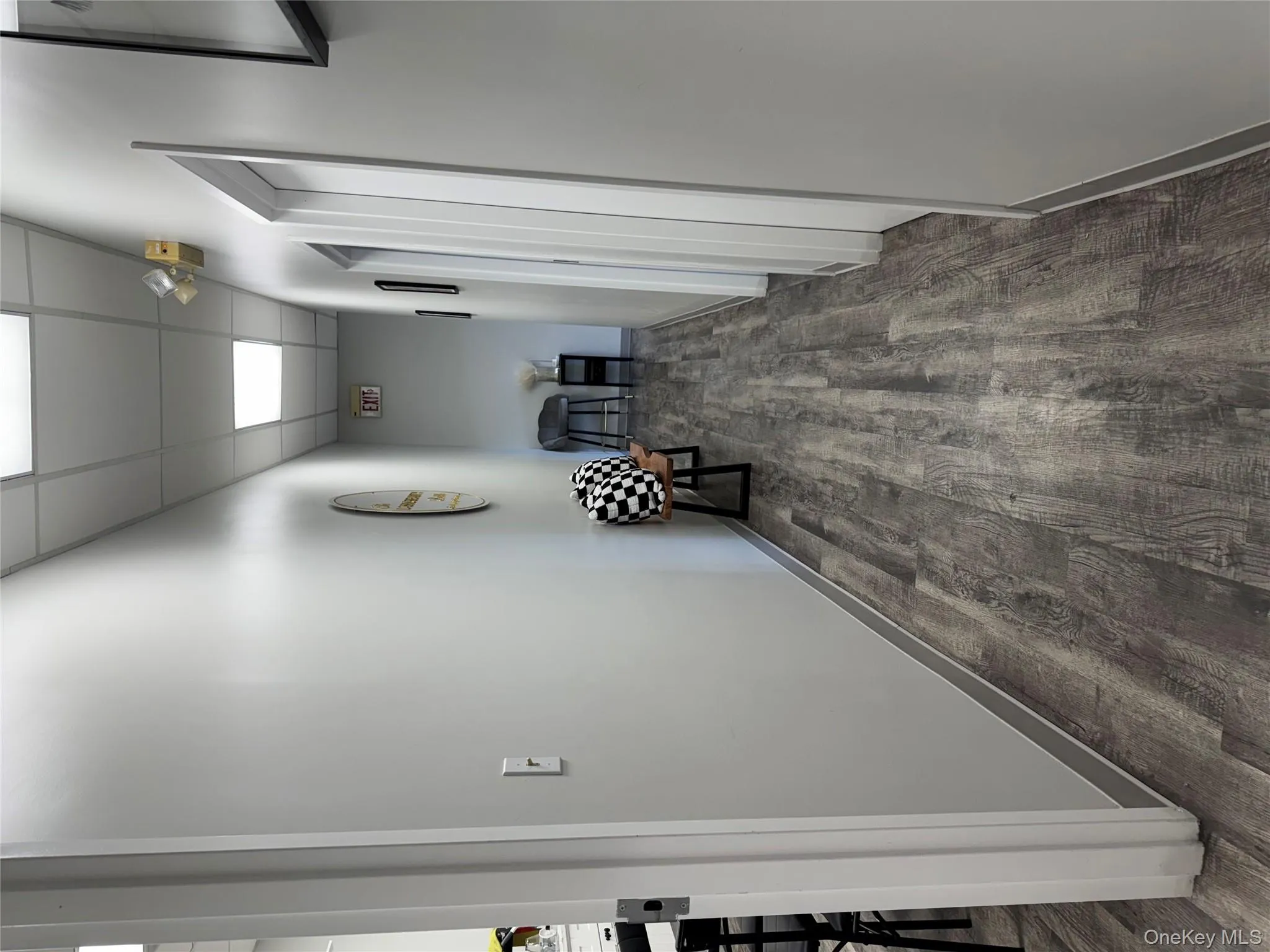 Corridor featuring a paneled ceiling and dark wood-style floors Corridor featuring a paneled ceiling and dark wood-style floors