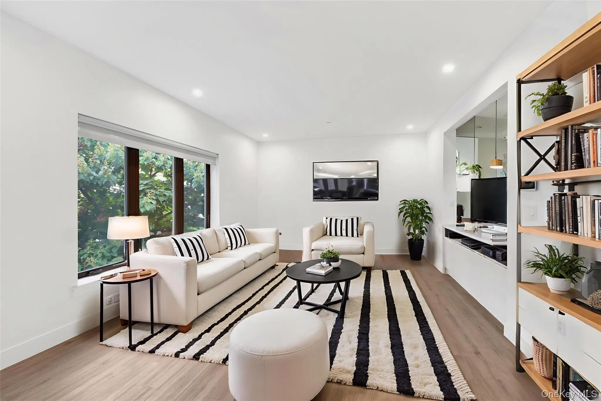 Living area featuring light wood-style flooring and recessed lighting Living area featuring light wood-style flooring and recessed lighting