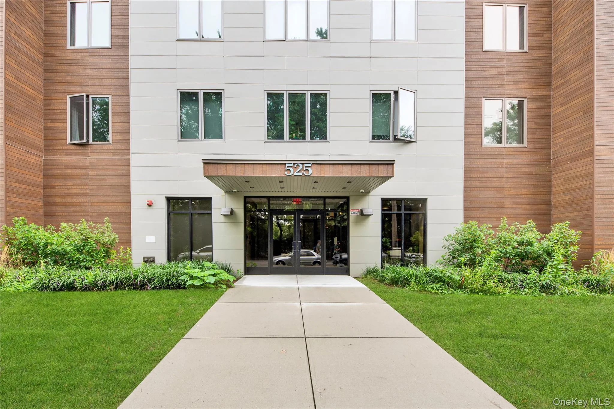 View of exterior entry featuring french doors and a yard View of exterior entry featuring french doors and a yard