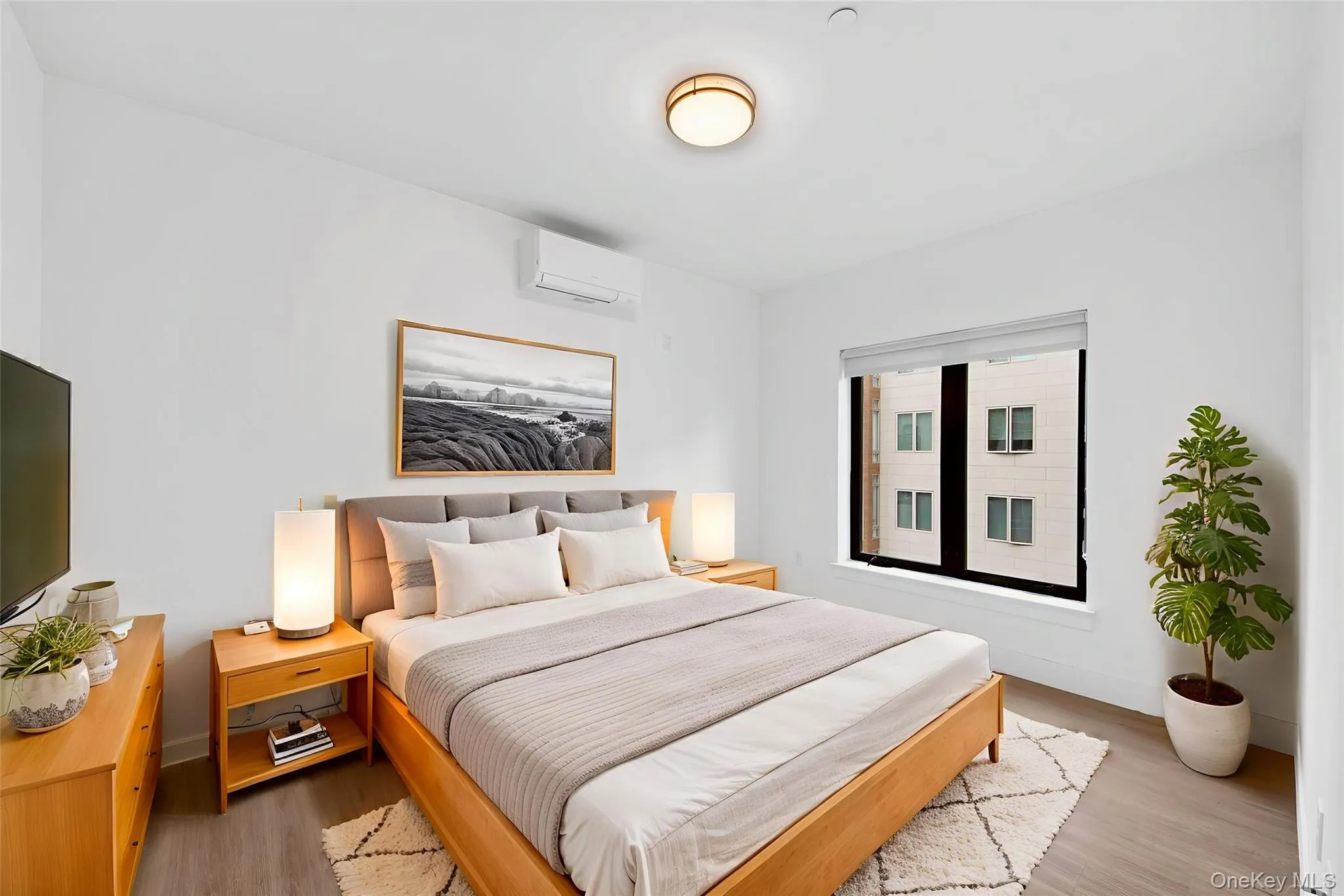 Bedroom featuring wood finished floors and a wall unit AC Bedroom featuring wood finished floors and a wall unit AC