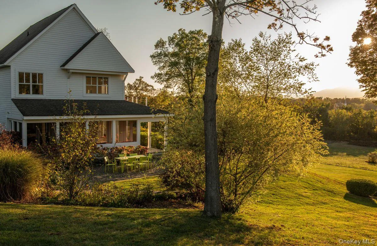 View of side of property featuring a yard, covered porch, and roof with shingles View of side of property featuring a yard, covered porch, and roof with shingles
