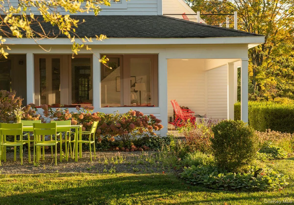 Rear view of house with a shingled roof and a lawn Rear view of house with a shingled roof and a lawn