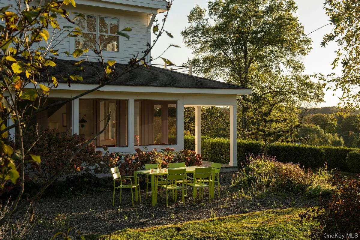 Back of house with a sunroom and a shingled roof Back of house with a sunroom and a shingled roof