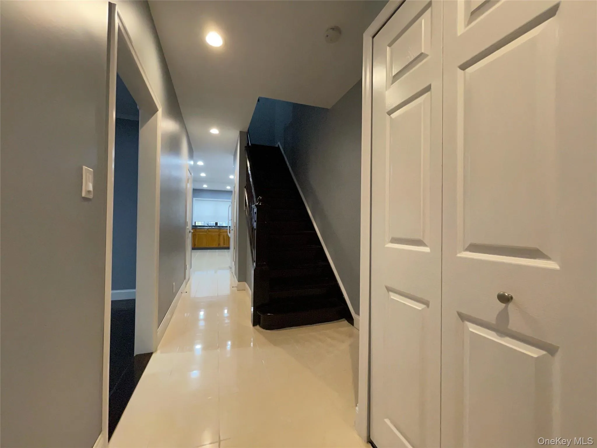 Corridor featuring recessed lighting, light tile patterned floors, and stairs Corridor featuring recessed lighting, light tile patterned floors, and stairs