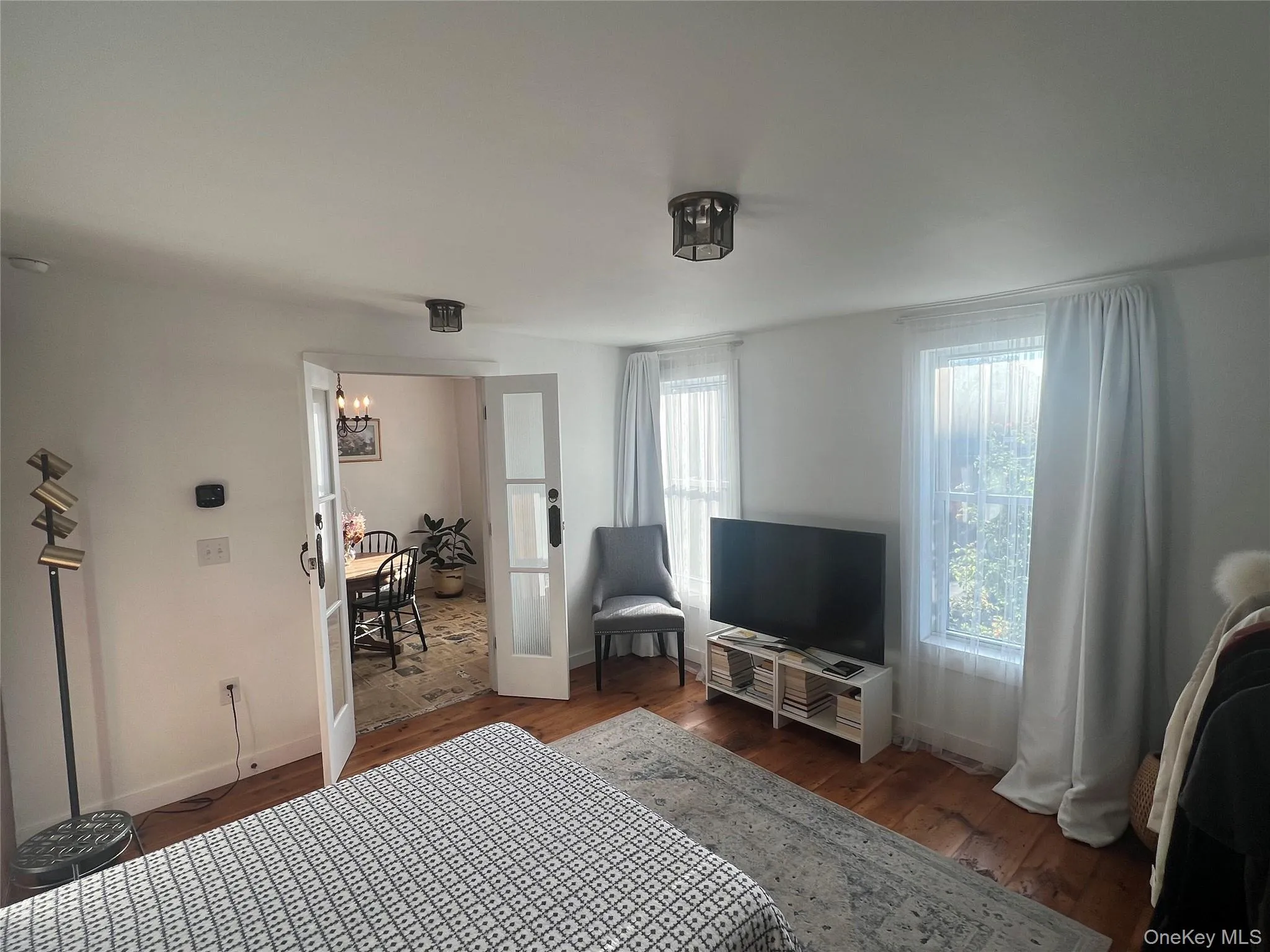 Bedroom with dark wood-style floors and a chandelier Bedroom with dark wood-style floors and a chandelier