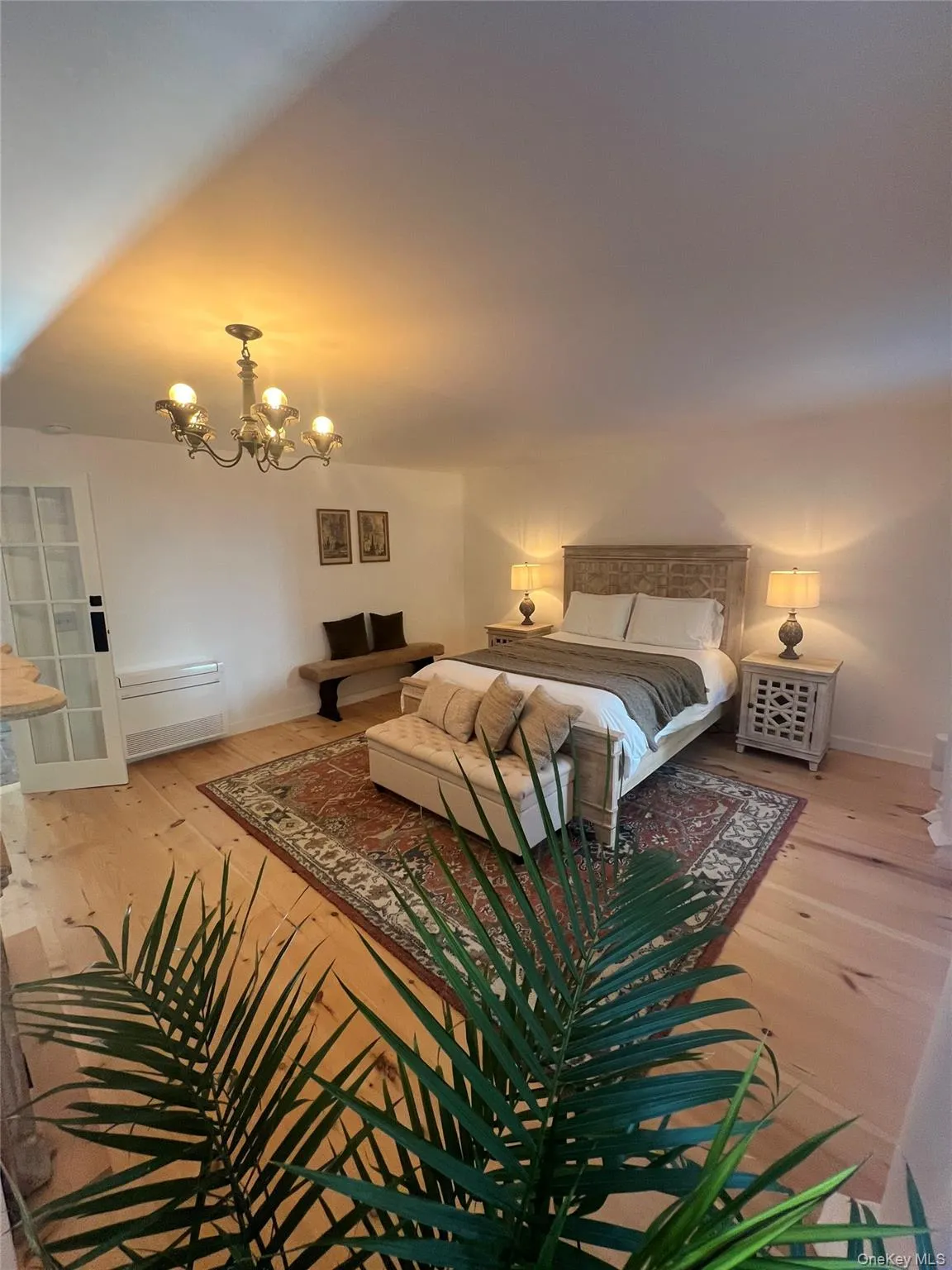Primary Bedroom with light wood flooring and a chandelier Primary Bedroom with light wood flooring and a chandelier