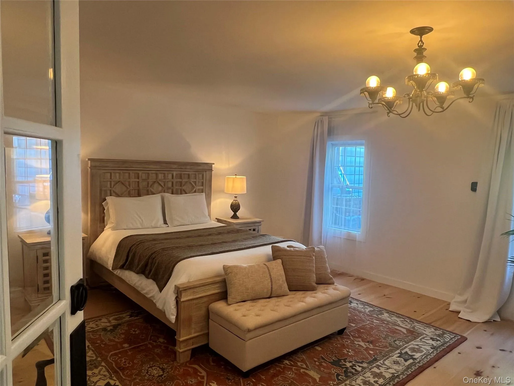 Primary Bedroom with wood finished floors and a chandelier Primary Bedroom with wood finished floors and a chandelier