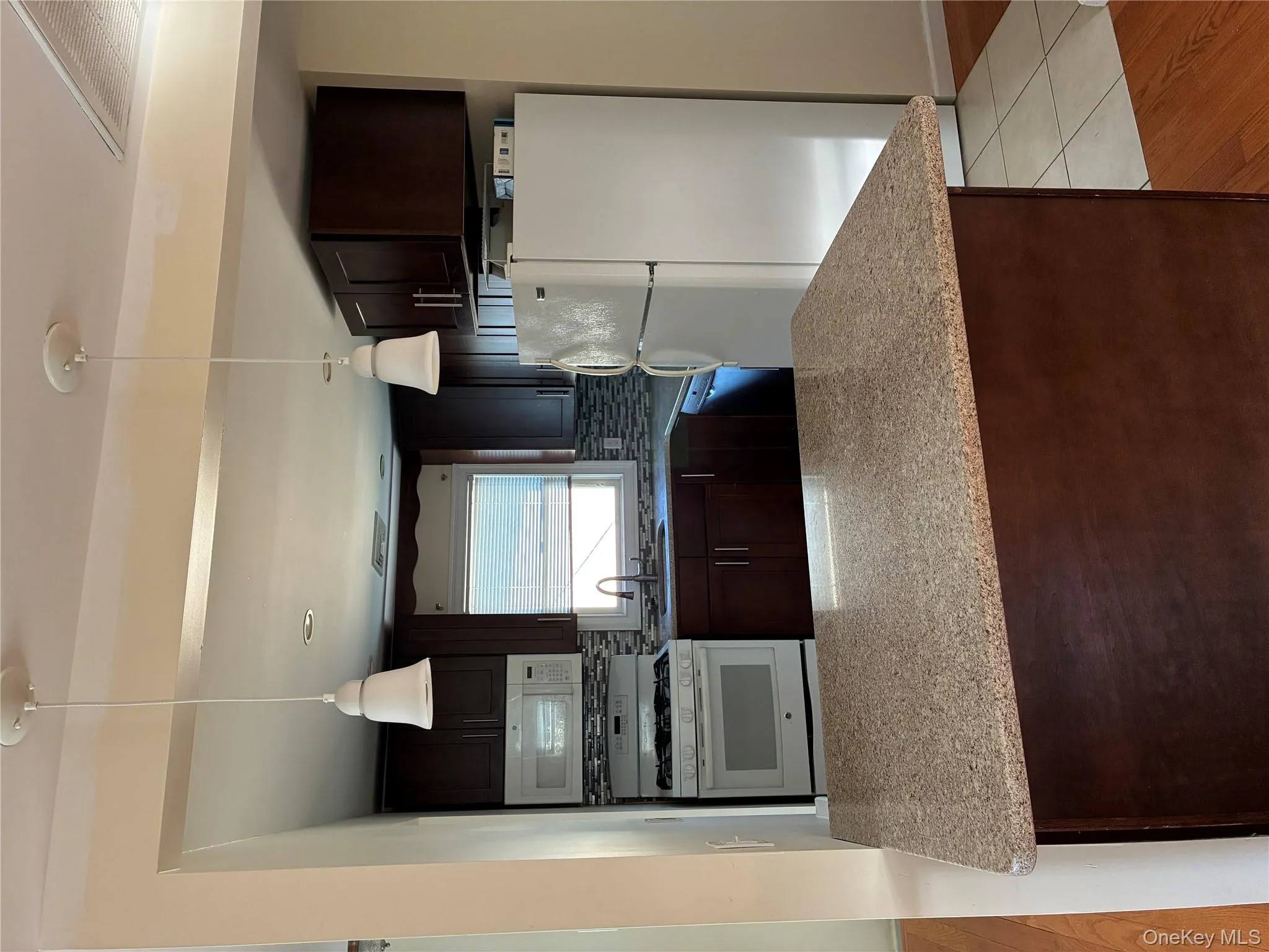 Kitchen featuring dark brown cabinetry, stove, white refrigerator, and decorative backsplash Kitchen featuring dark brown cabinetry, stove, white refrigerator, and decorative backsplash