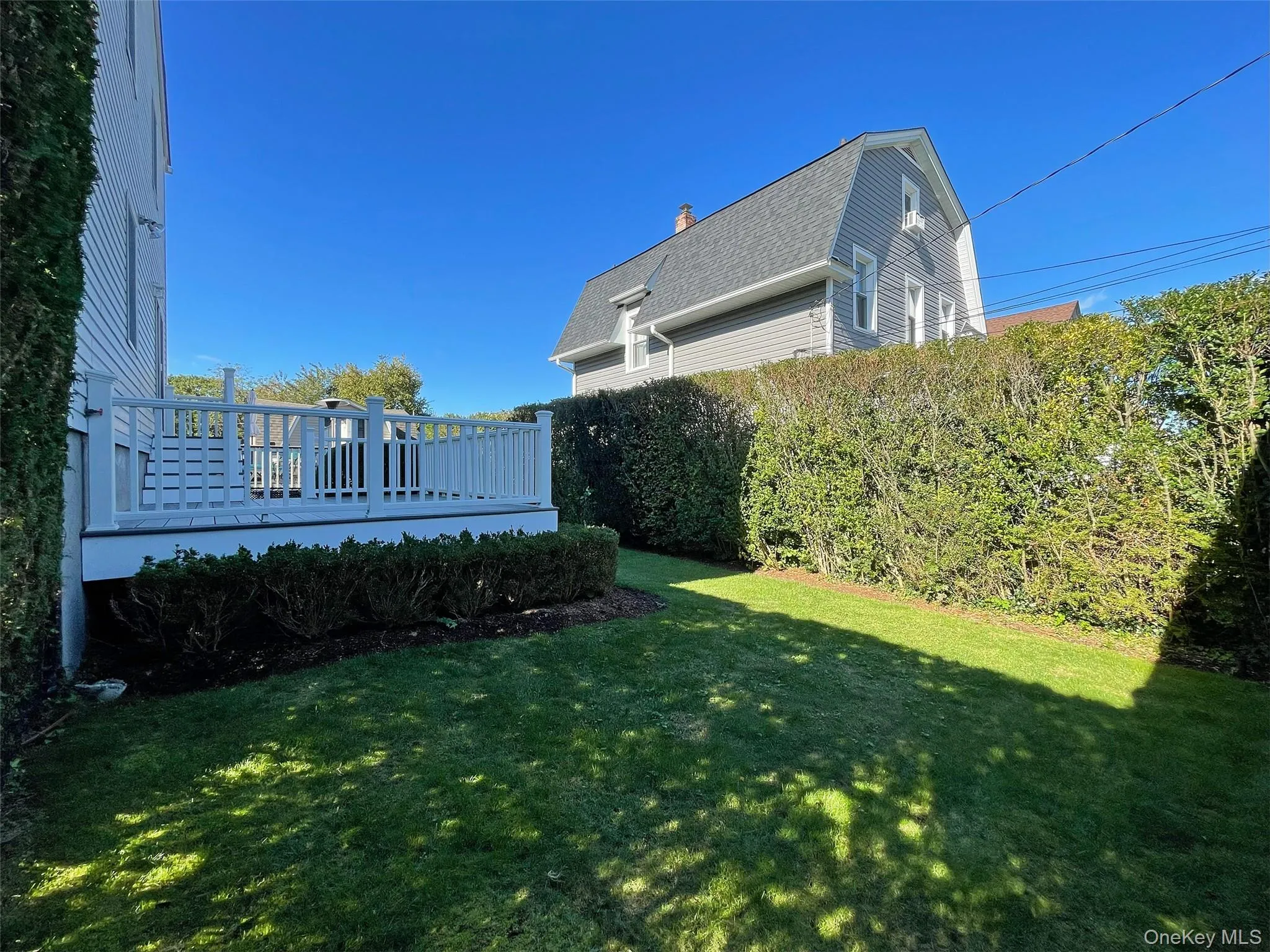 View of green lawn with a wooden deck View of green lawn with a wooden deck