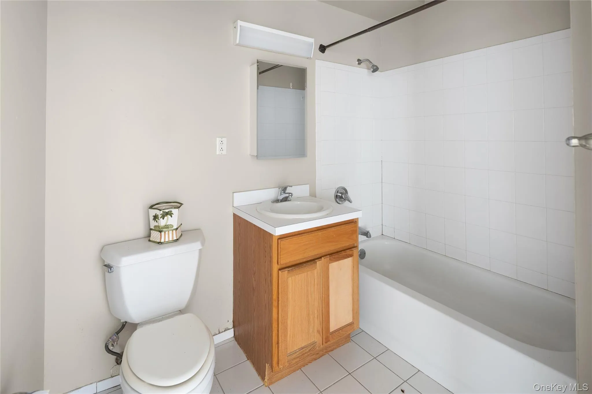 Full bath with shower / washtub combination, vanity, and light tile patterned floors Full bath with shower / washtub combination, vanity, and light tile patterned floors