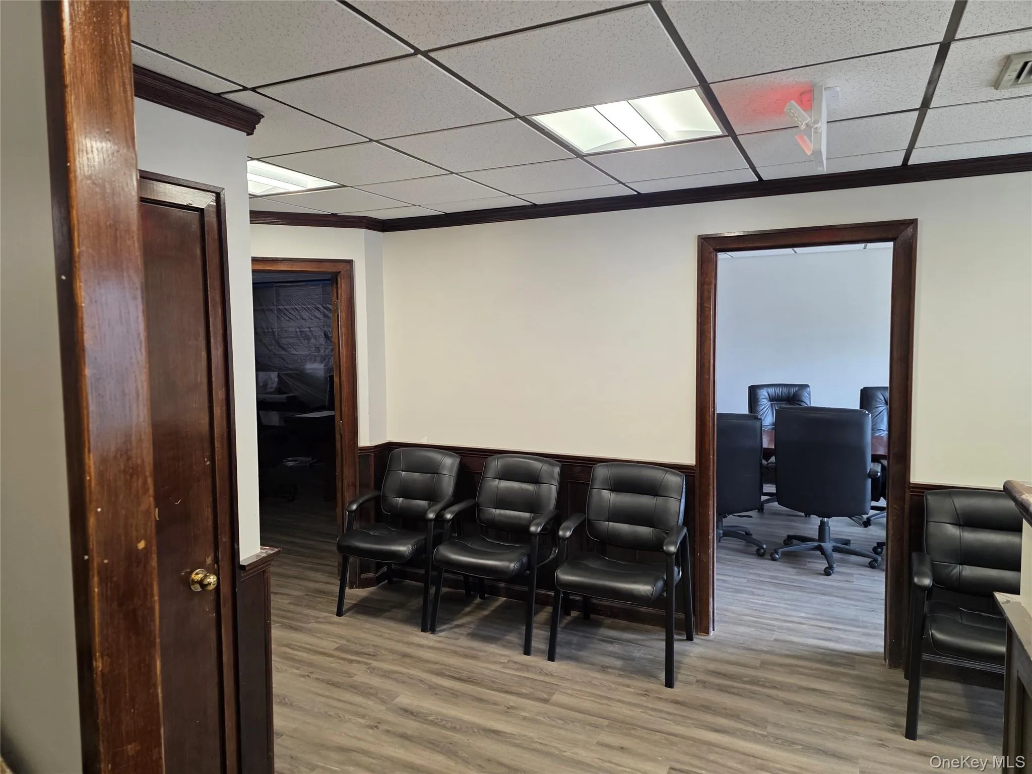 Home theater room featuring light wood finished floors, crown molding, and a drop ceiling Home theater room featuring light wood finished floors, crown molding, and a drop ceiling