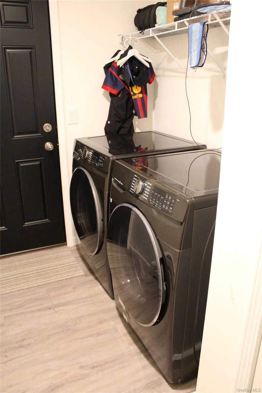 Laundry room with separate washer and dryer and light wood-style floors Laundry room with separate washer and dryer and light wood-style floors