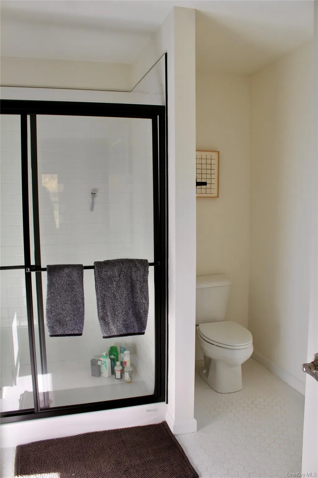 Bathroom featuring tile patterned floors and a shower stall Bathroom featuring tile patterned floors and a shower stall