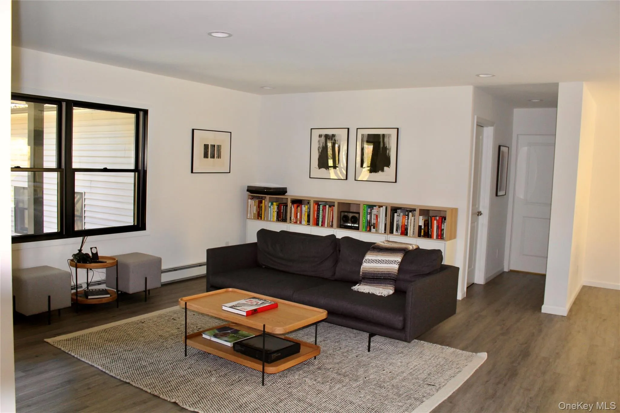 Living area featuring recessed lighting, a baseboard radiator, and dark wood-type flooring Living area featuring recessed lighting, a baseboard radiator, and dark wood-type flooring