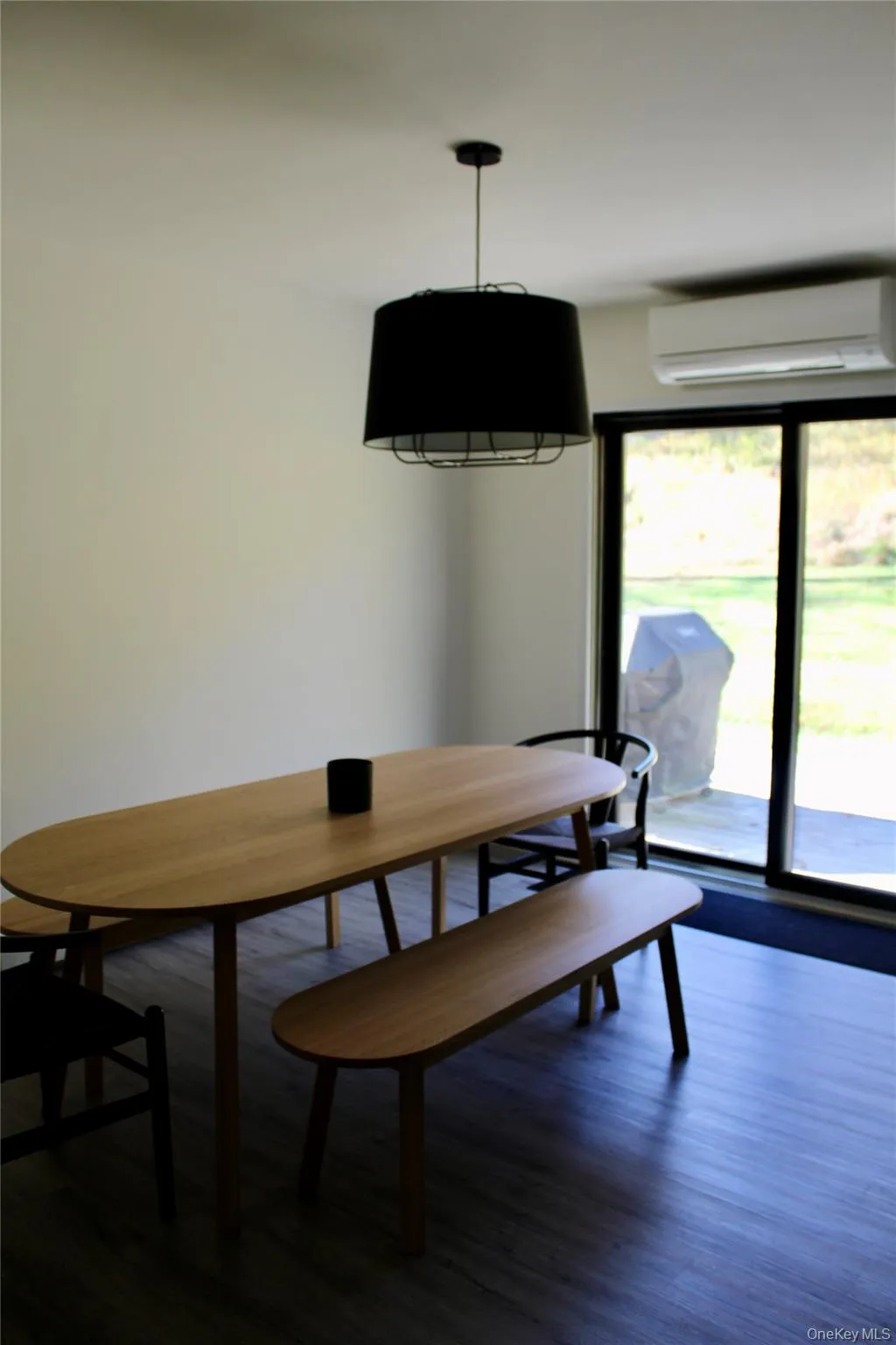 Dining space featuring dark wood-style flooring and an AC wall unit Dining space featuring dark wood-style flooring and an AC wall unit