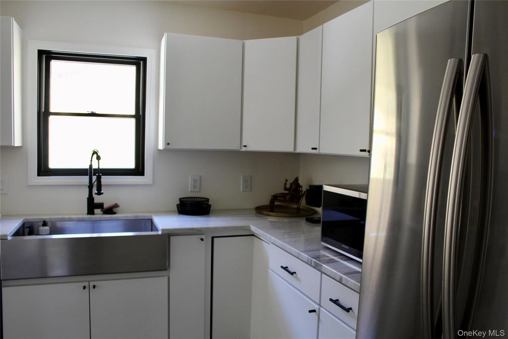 Kitchen featuring appliances with stainless steel finishes and white cabinets Kitchen featuring appliances with stainless steel finishes and white cabinets