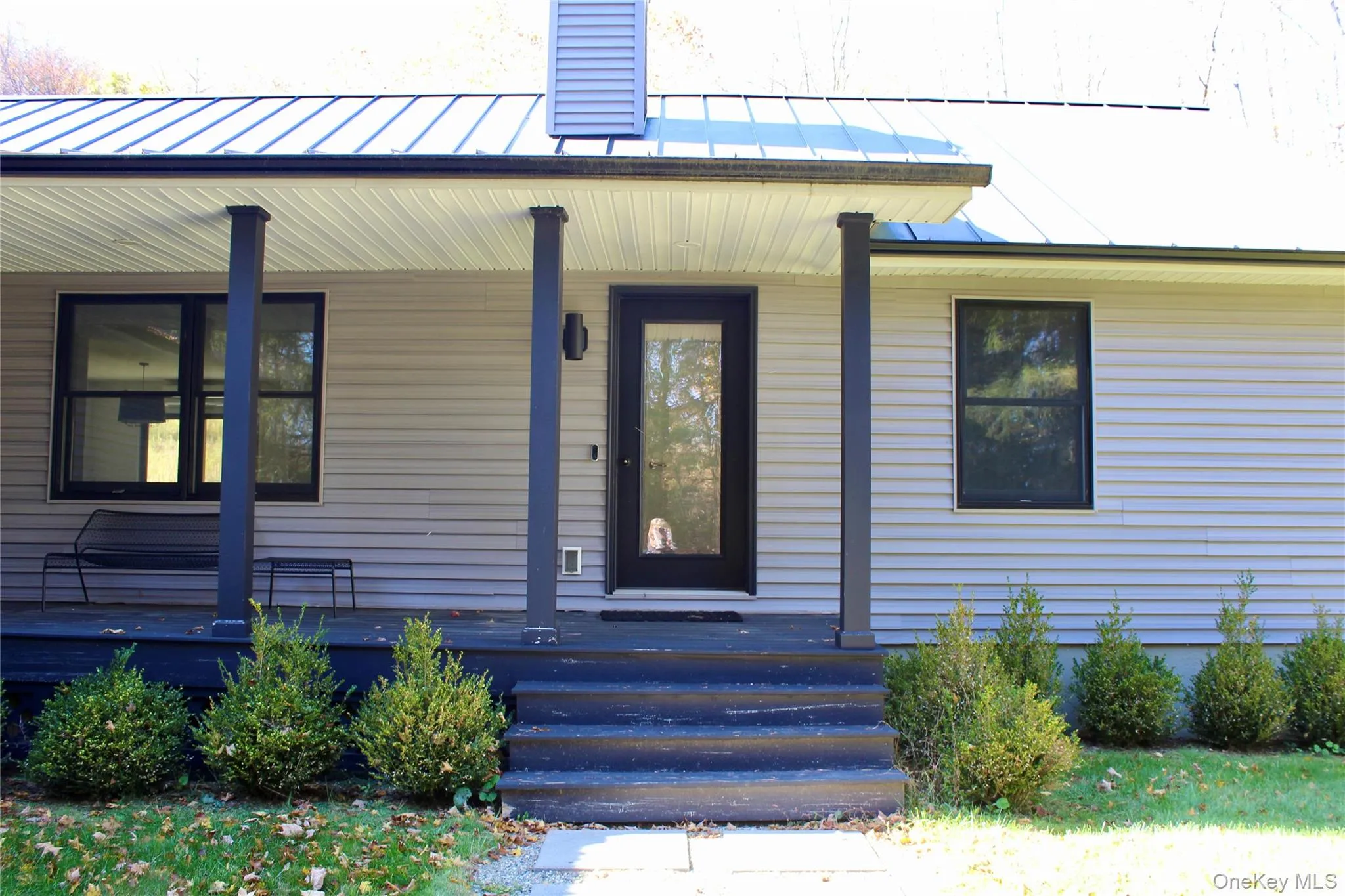 Doorway to property with a porch and a metal roof Doorway to property with a porch and a metal roof