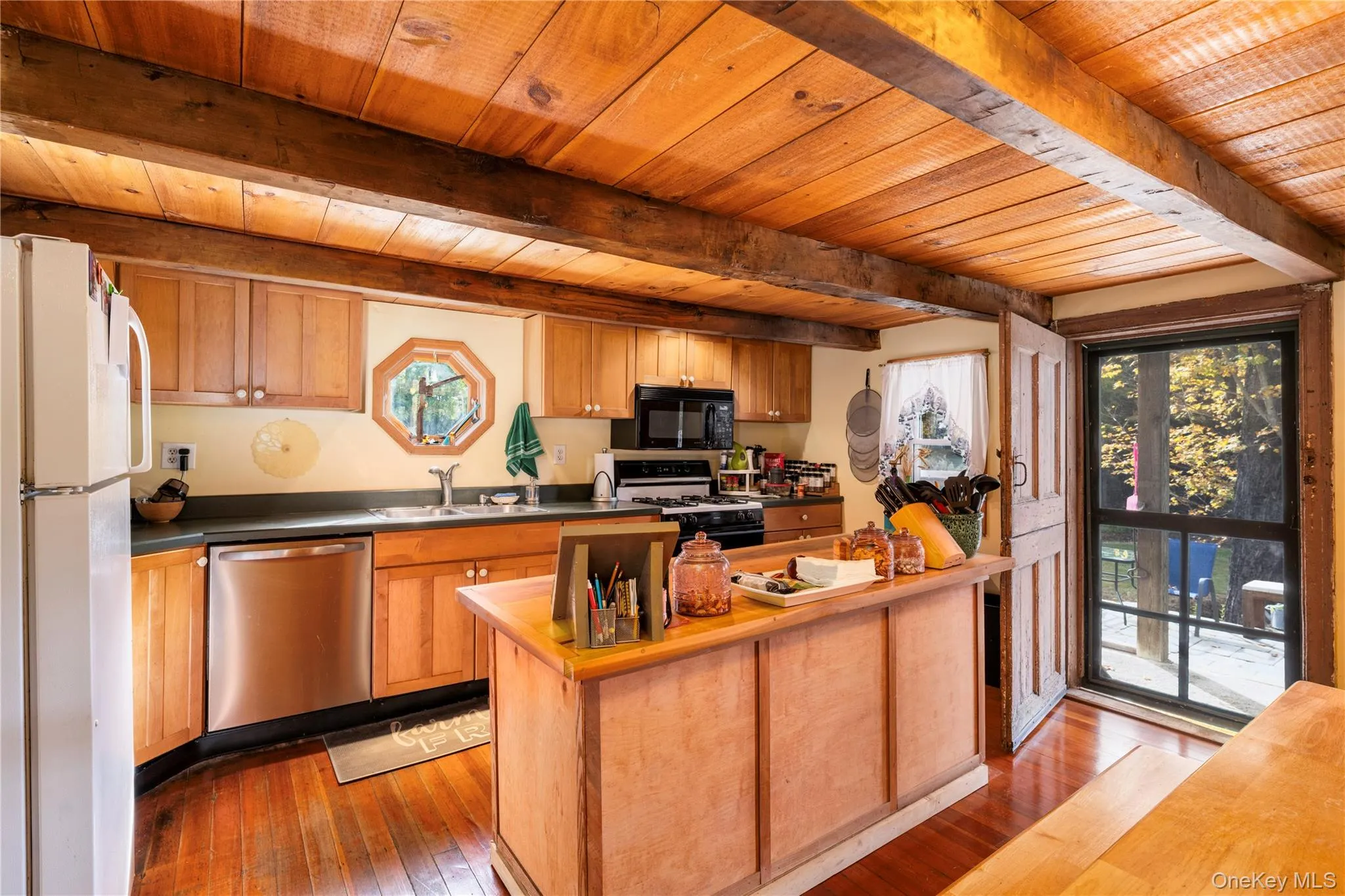 Kitchen featuring wood counters, freestanding refrigerator, dishwasher, light wood-type flooring, and range with gas stovetop Kitchen featuring wood counters, freestanding refrigerator, dishwasher, light wood-type flooring, and range with gas stovetop