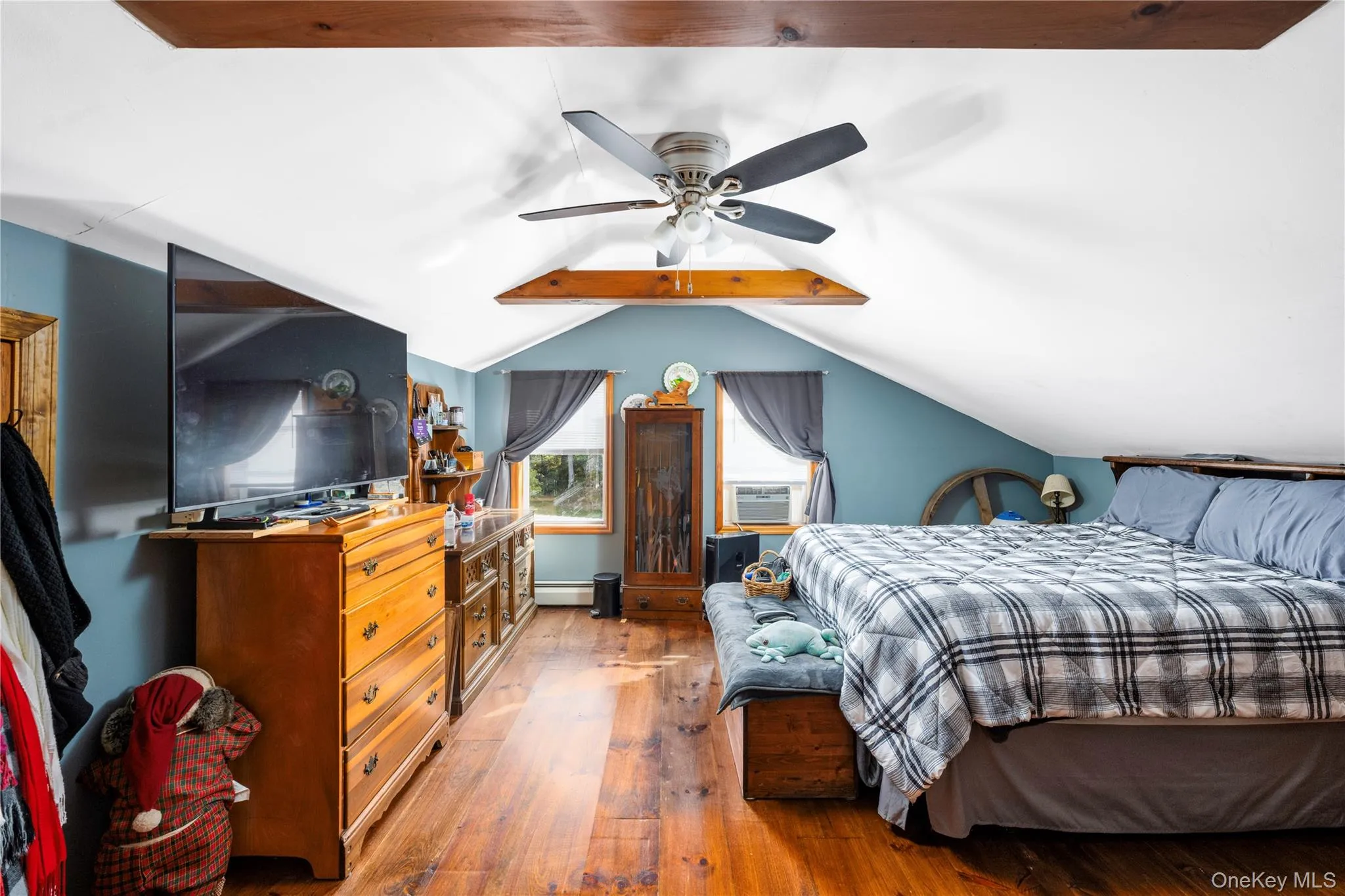 Bedroom with hardwood / wood-style flooring, a ceiling fan, cooling unit, and a baseboard heating unit Bedroom with hardwood / wood-style flooring, a ceiling fan, cooling unit, and a baseboard heating unit