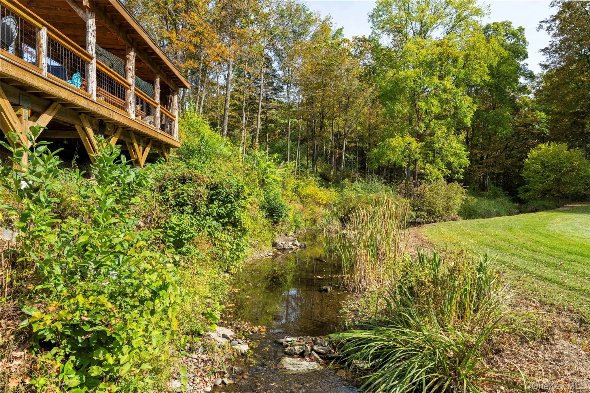 View of grassy yard featuring a wooden deck View of grassy yard featuring a wooden deck
